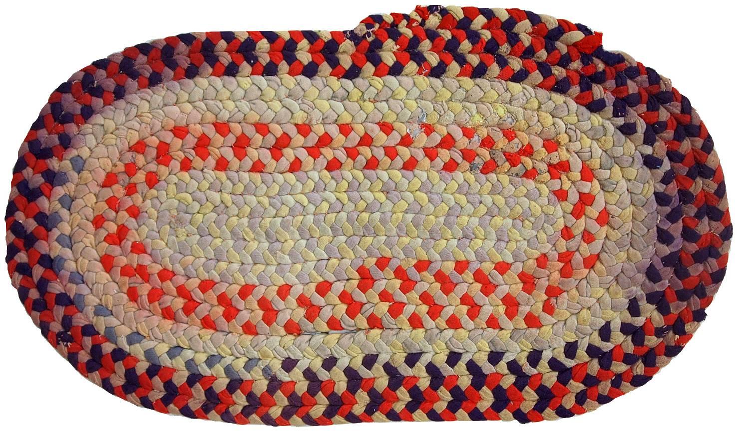 Antique handmade American Braided oval rug. The rug is in warn condition, it has discolouration issues and some little wears on cotton stripes. This piece of American craft could be very useful for a small areas of your house.
 