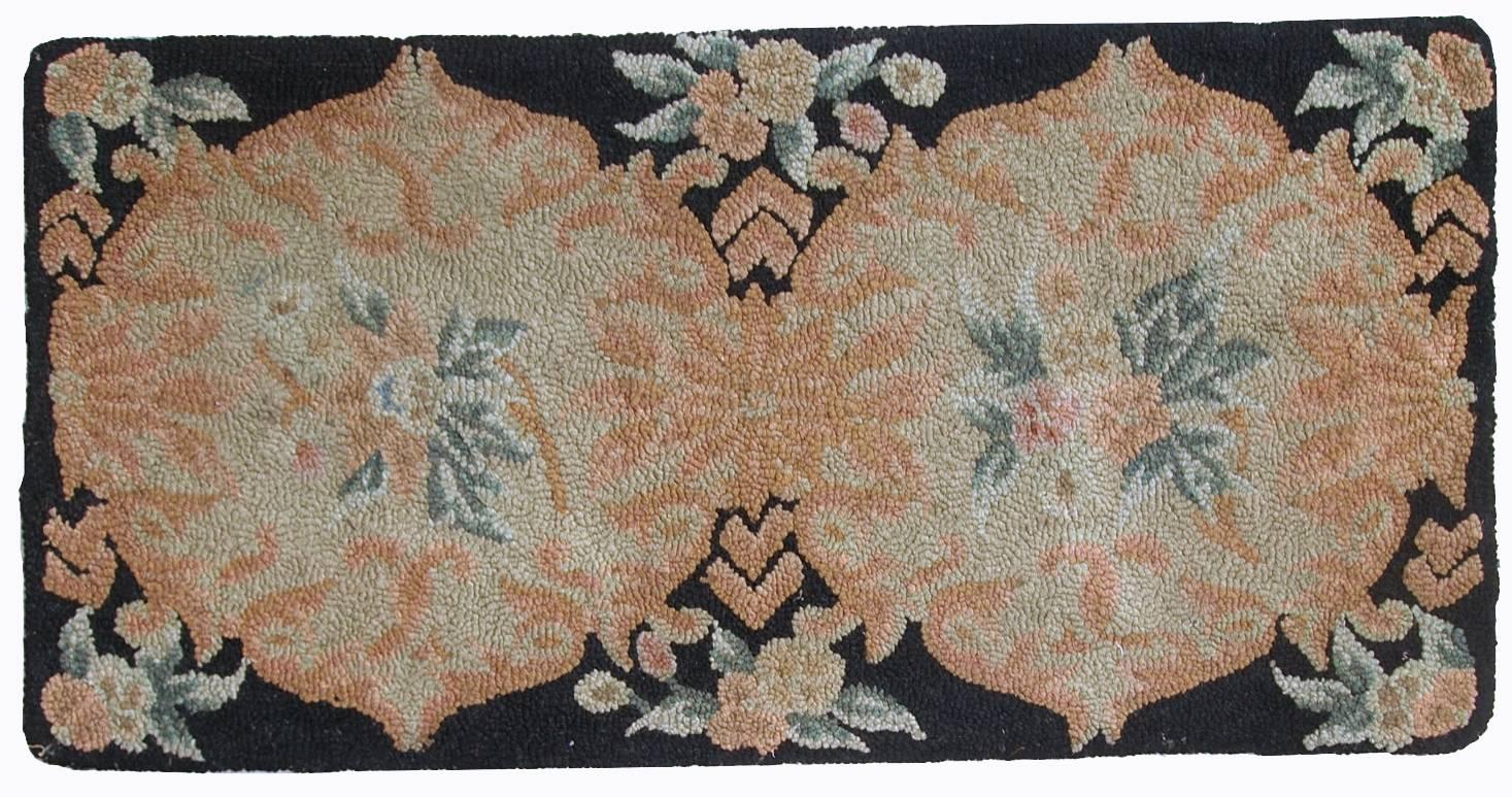 Vintage handmade American Hooked rug in black and peach shades. Two large circles with floral design. The rug is in original good condition.
 
