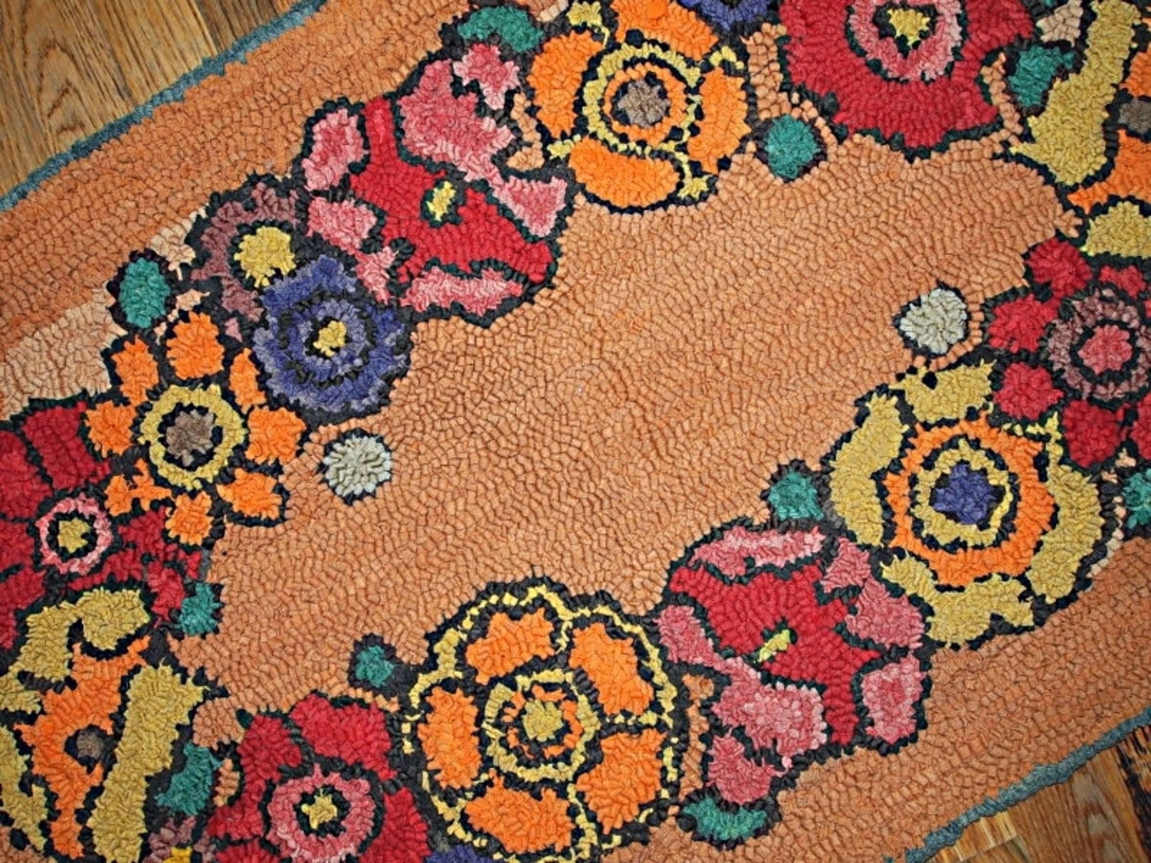 Antique American hooked rug in bright orange color. In each corner of it are clover shaped foliage in green shade. In the centre oval made from the colorful flowers. Very beautiful piece of American art.
 
