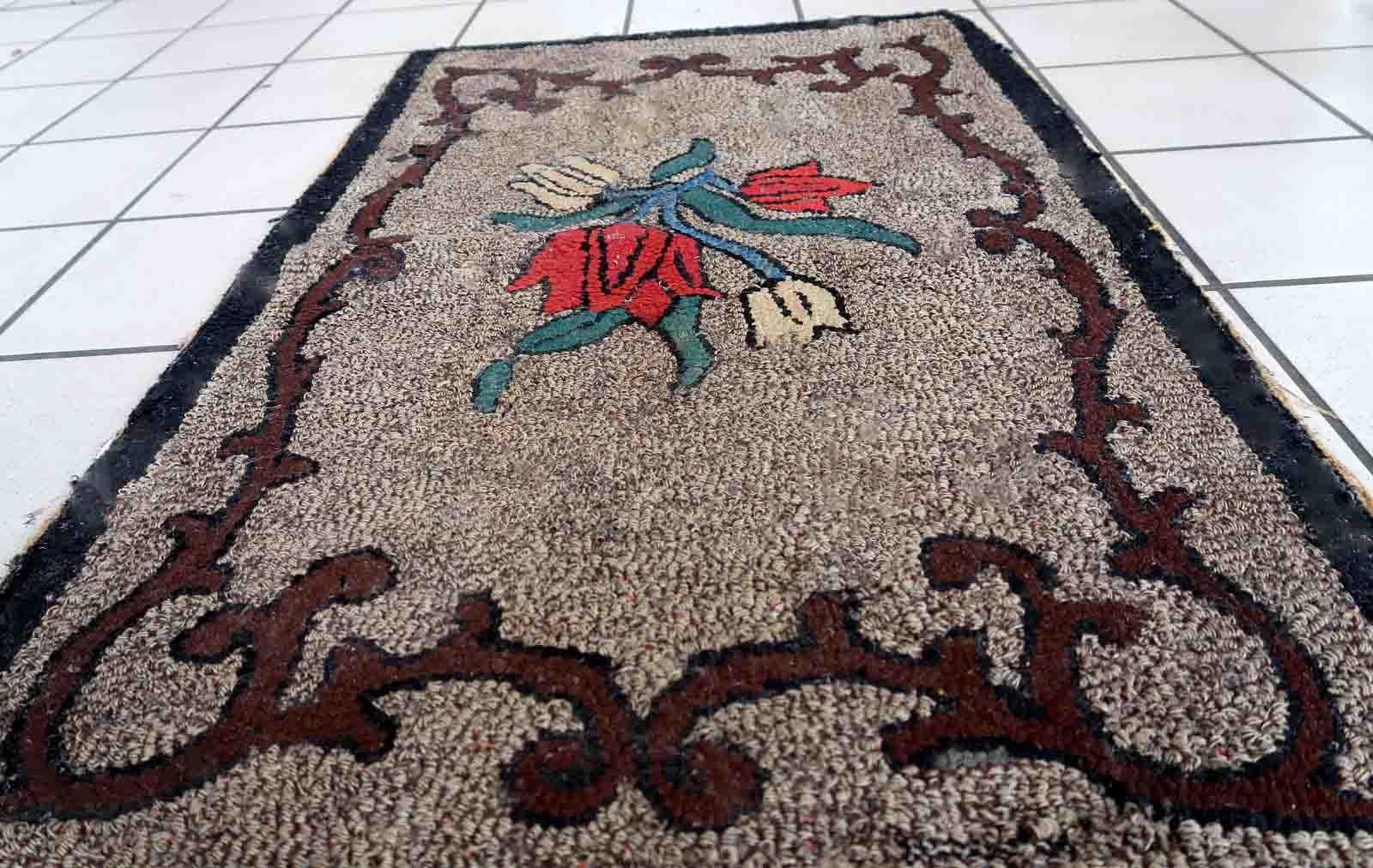 Handmade antique American Hooked rug in floral design. The rug is from the end of 19th century in good condition, the rug has old restorations.

-condition: good, restored,

-circa: 1880s,

-size: 2' x 3.3' (63cm x 101cm),

-material: