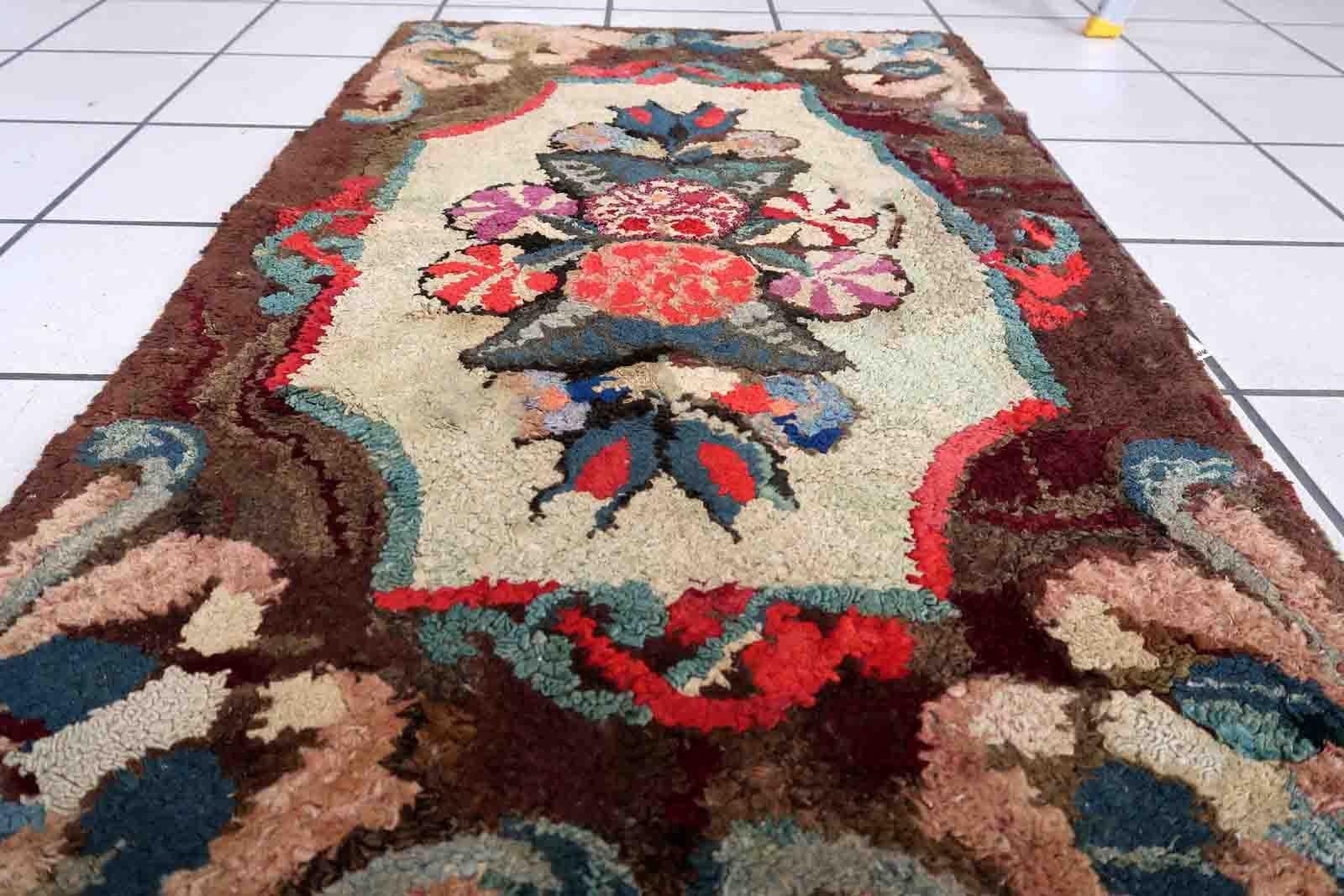 Handmade antique American Hooked rug in floral design. The rug is from the end of 19th century. It is in good condition, has some old restorations.

-condition: restored,

-circa: 1880s,

-size: 2' x 3.5' (63cm x 107cm),

-material: