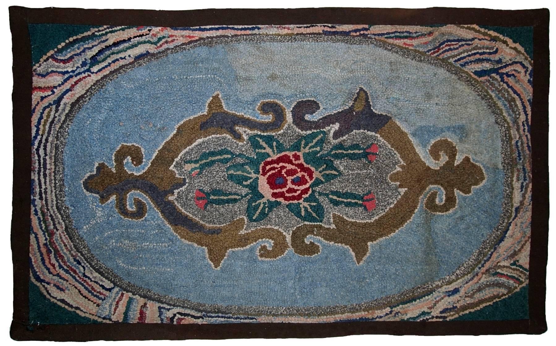Antique American hooked rug in sky blue shade. The rug has some age discolorations.
 