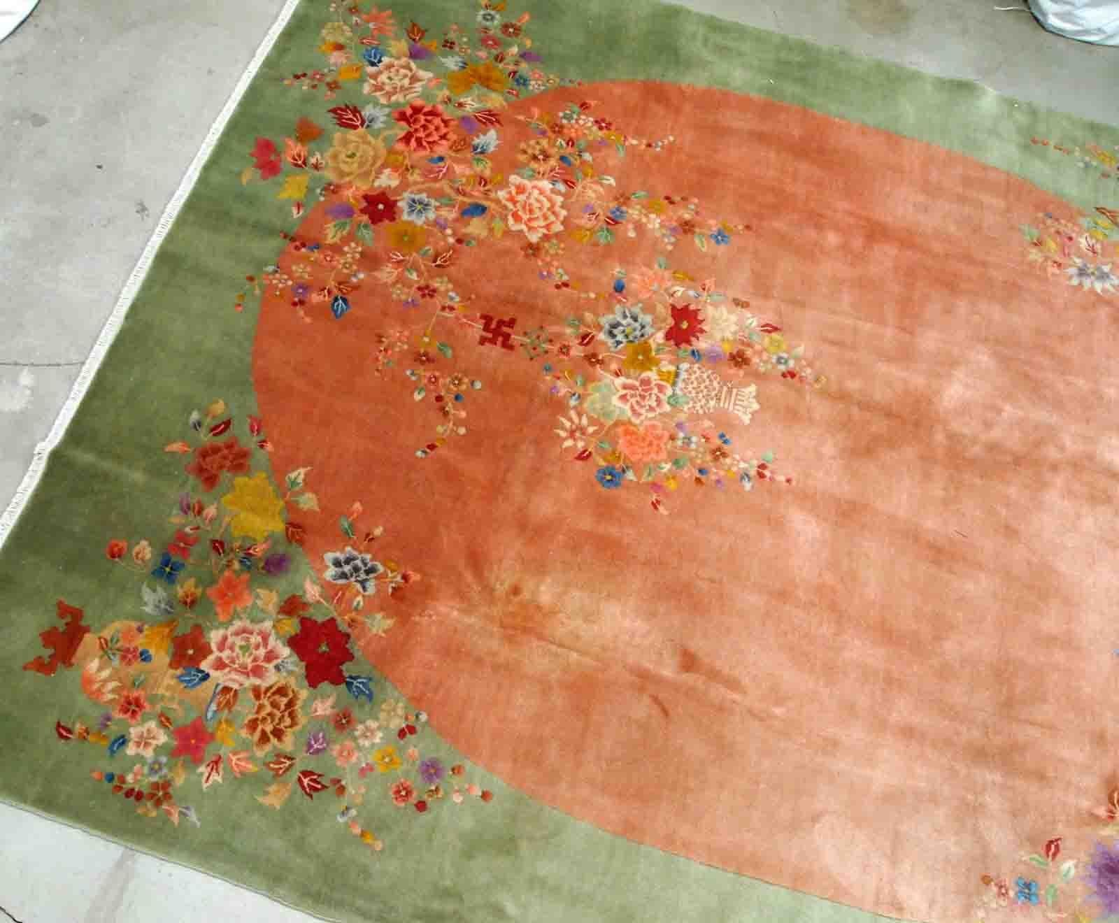 Handmade antique Art Deco Chinese rug in orange and green colours. The rug is from the end of 20th century in original good condition. The rug has a symbol of Indian swastic.

-Condition: original good,

-circa: 1920s,

-Size: 9.1' x 11.6'