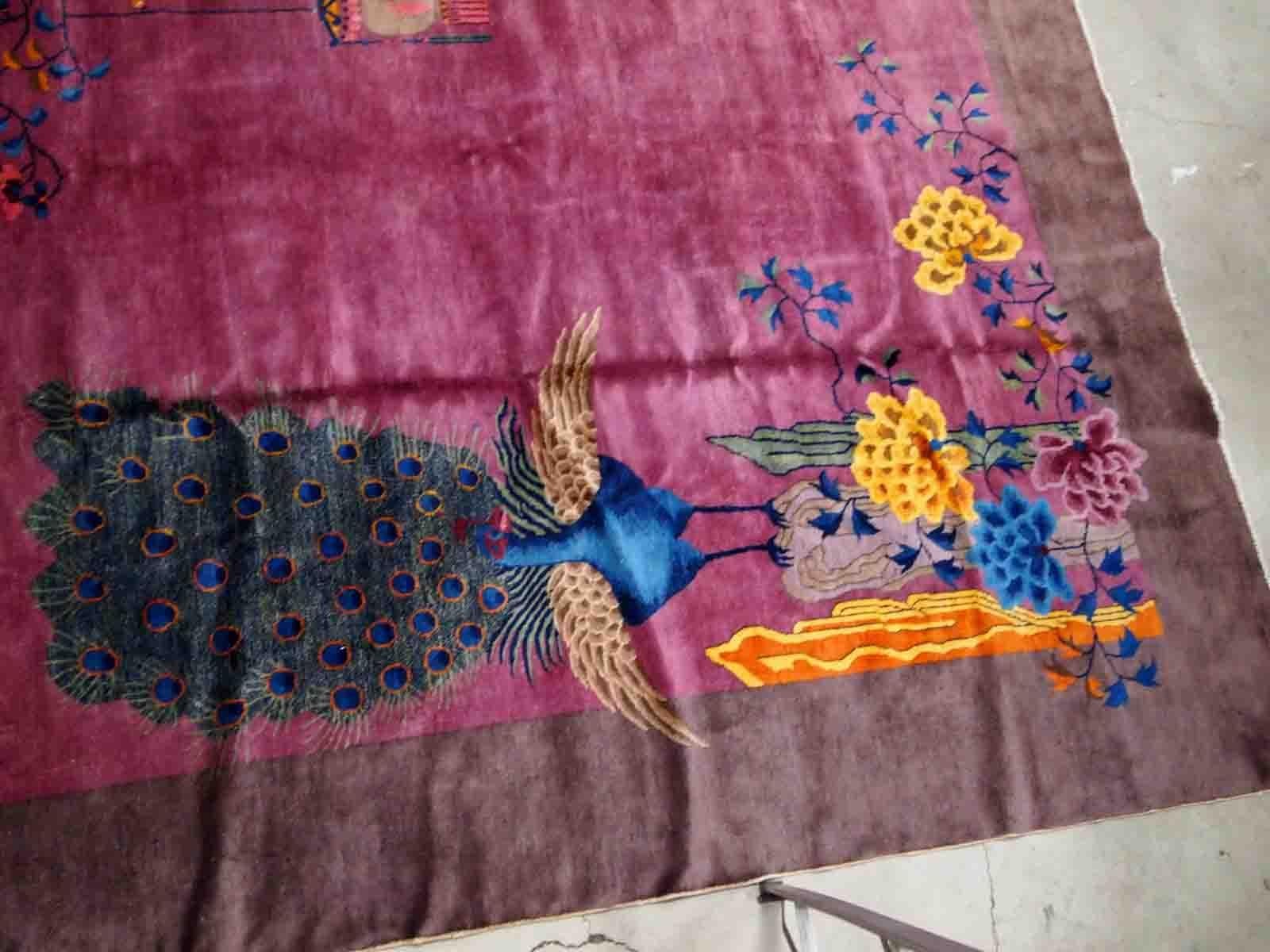 Handmade antique Art Deco Chinese rug in ruby and burgundy shades. The rug is from the beginning of 20th century in original good condition. It has some floral accent with large peacock on it.

-condition: original good,

-circa: