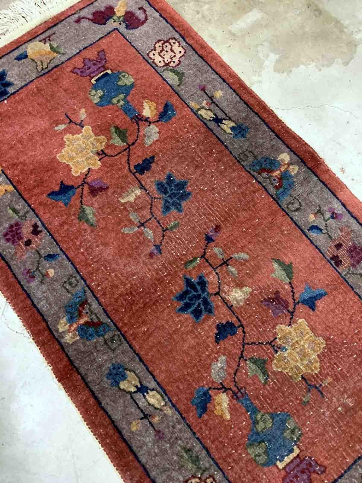 Handmade antique Art Deco Chinese rug in red shade with greyish border. The rug has traditional floral Art Deco design. It is from the beginning of 20th century in original condition, it has some low pile.

-condition: original, some low