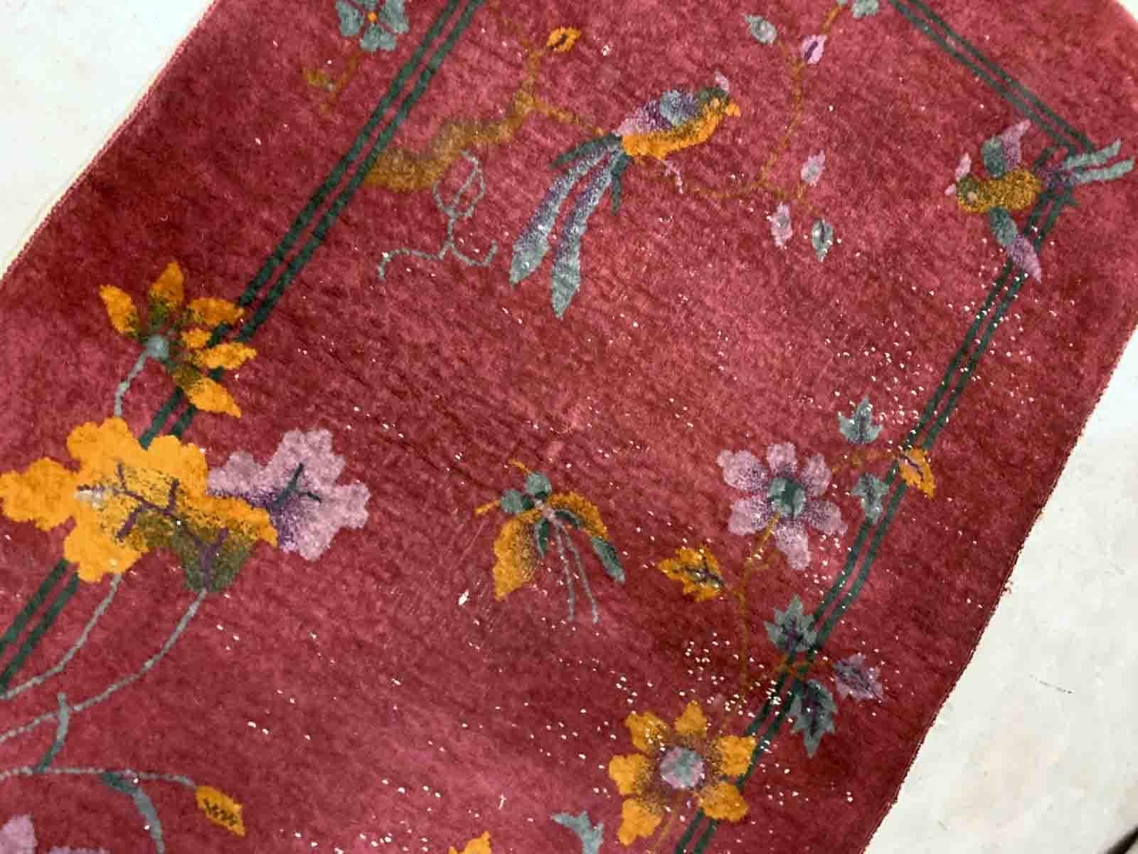 Handmade antique Art Deco Chinese rug in red color. The rug has traditional floral Art Deco design with some birds and vases. It is from the beginning of 20th century in original condition, it has some low pile.

-condition: original, some low
