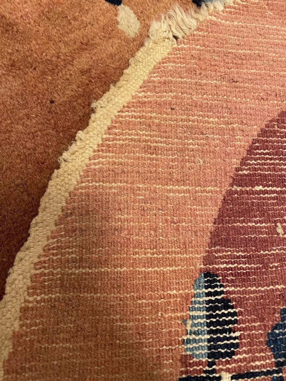 This handmade antique Art Deco Chinese rug from the 1920s is a beautiful example of traditional craftsmanship. Measuring 2 feet (60 cm) in width and 3.8 feet (115 cm) in length, this exquisite wool rug is in good condition and showcases intricate