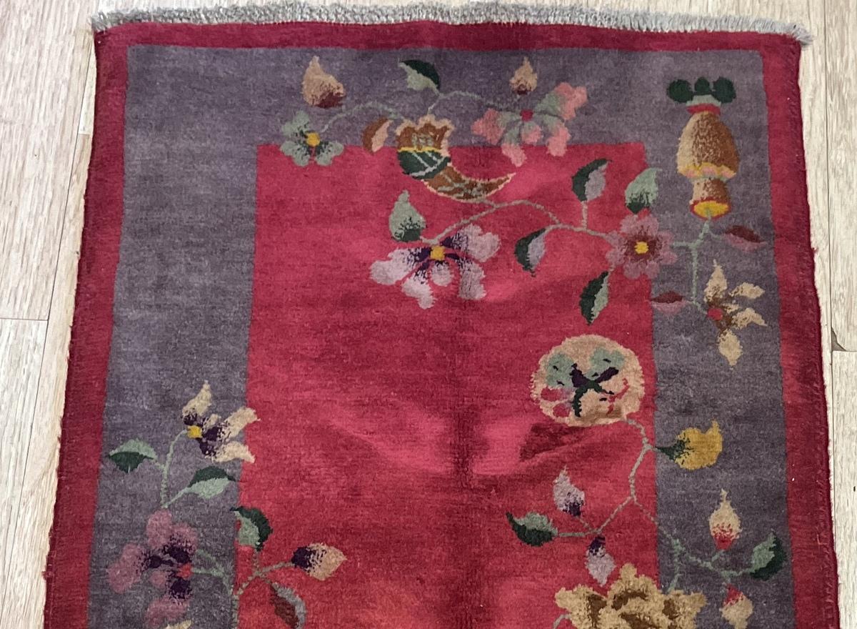 Ce superbe tapis chinois antique Arte Antiques des années 1920 est un chef-d'œuvre fait à la main en laine de haute qualité. Doté d'un riche champ central rouge encadré d'une bordure marron foncé, ce tapis est orné d'élégants motifs floraux et