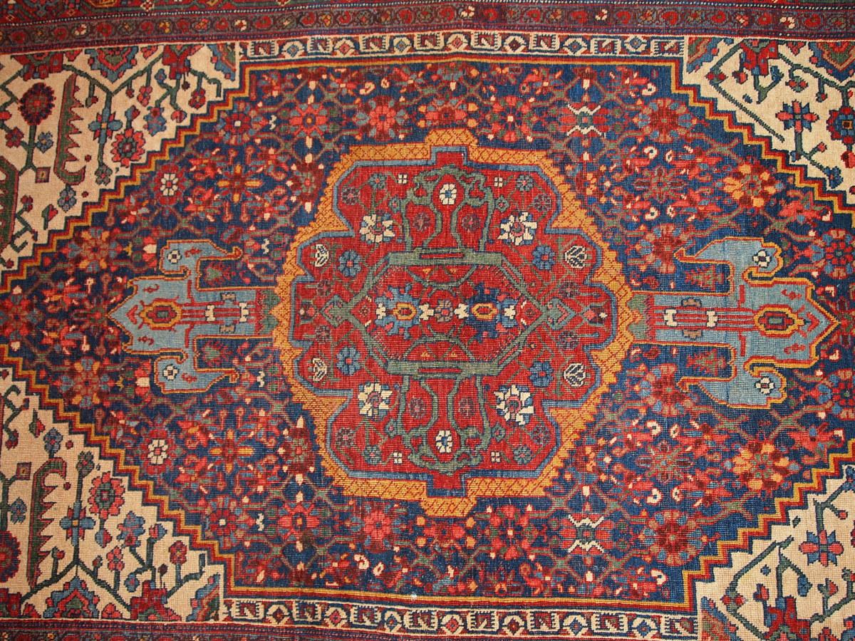 Ancien tapis persan Bidjar fait à la main, en bon état d'origine. Le tapis est de conception traditionnelle dans des tons rouge, marine et blanc.