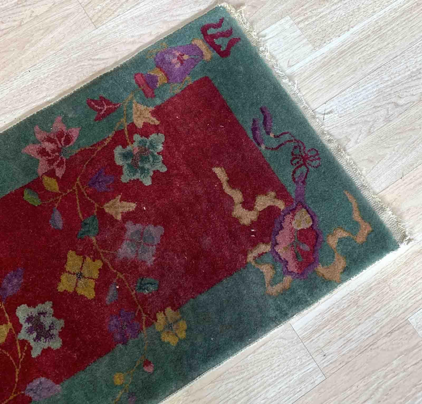This exquisite Art Deco Chinese rug from the 1920s is a true work of art. Handmade with meticulous attention to detail, it features a captivating design in rich, vibrant colors. The background colors of deep red, grass green, purple, beige, and