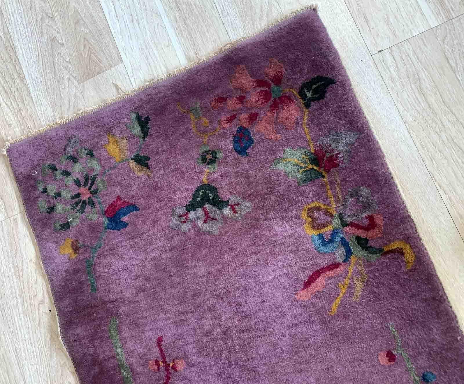 This handmade antique Chinese rug from the 1920s is a stunning example of Art Deco design. With its compact size of 2.2' x 4.1' (67cm x 124cm), it is perfect for adding a touch of vintage elegance to any space. The rug is crafted from high-quality