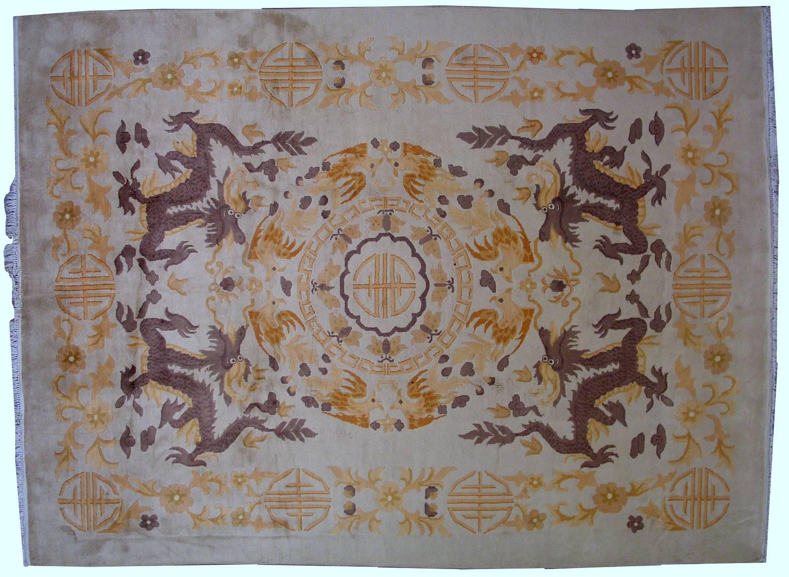 Handmade antique Art Deco Chinese rug in original condition. The rug is very unusual for Art Deco type and in beige shade. The large circle with golden details in the centre as medallion. Four brown dragons are around it. The border is in decorative
