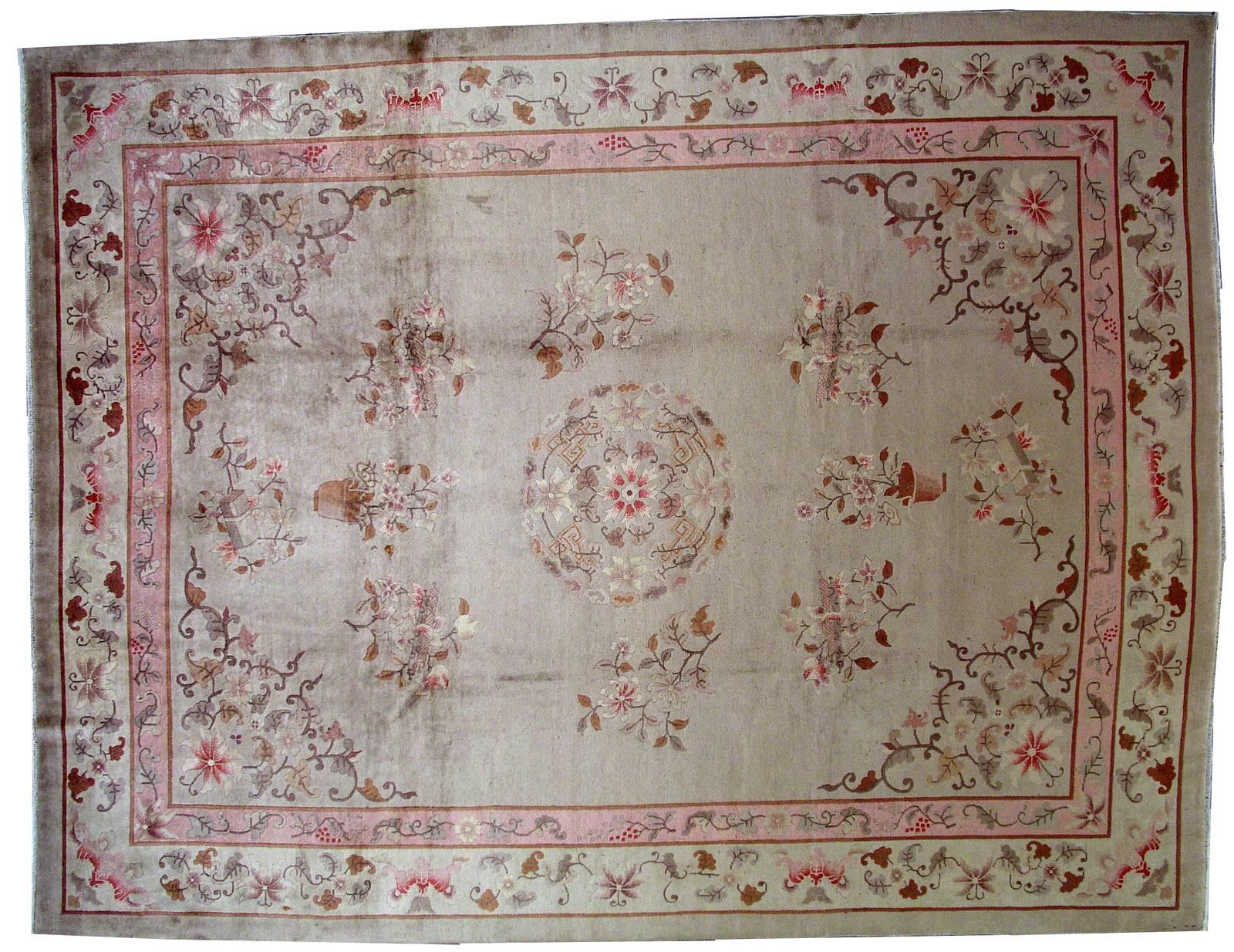 Handmade antique Art Deco Chinese rug in original condition. The rug made in light shades of beige, pink, brown and burgundy. Floral design with round medallion in the centre. Beautiful pink inner border is following after larger beige border