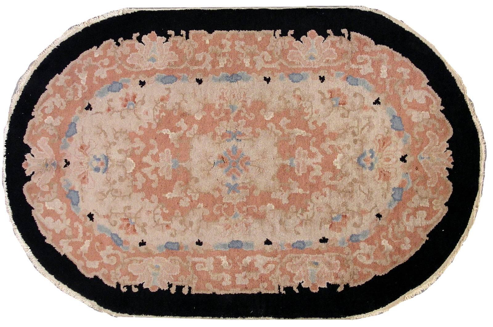 Handmade antique oval Art Deco Chinese rug in original condition. This rug made in very soft shades of beige, sky blue and peach. Very decorative design and soft touch of taste. The border is in black colour. The rug is oval and in good