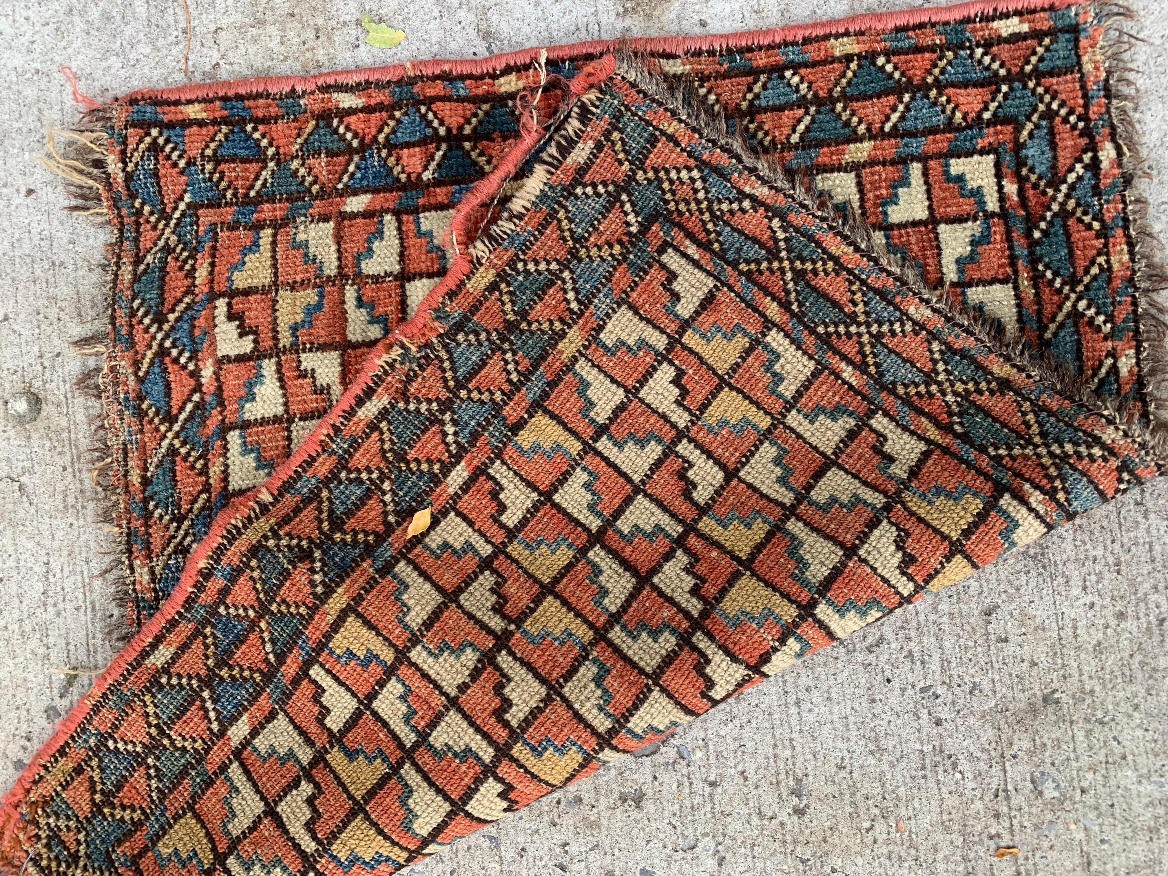 This handmade antique Bashir bagface rug, dating back to the 1870s, is a remarkable collectible piece, embodying the intricate artistry of Bashir weaving traditions. Its compact size and vibrant design make it a unique addition to any collection or