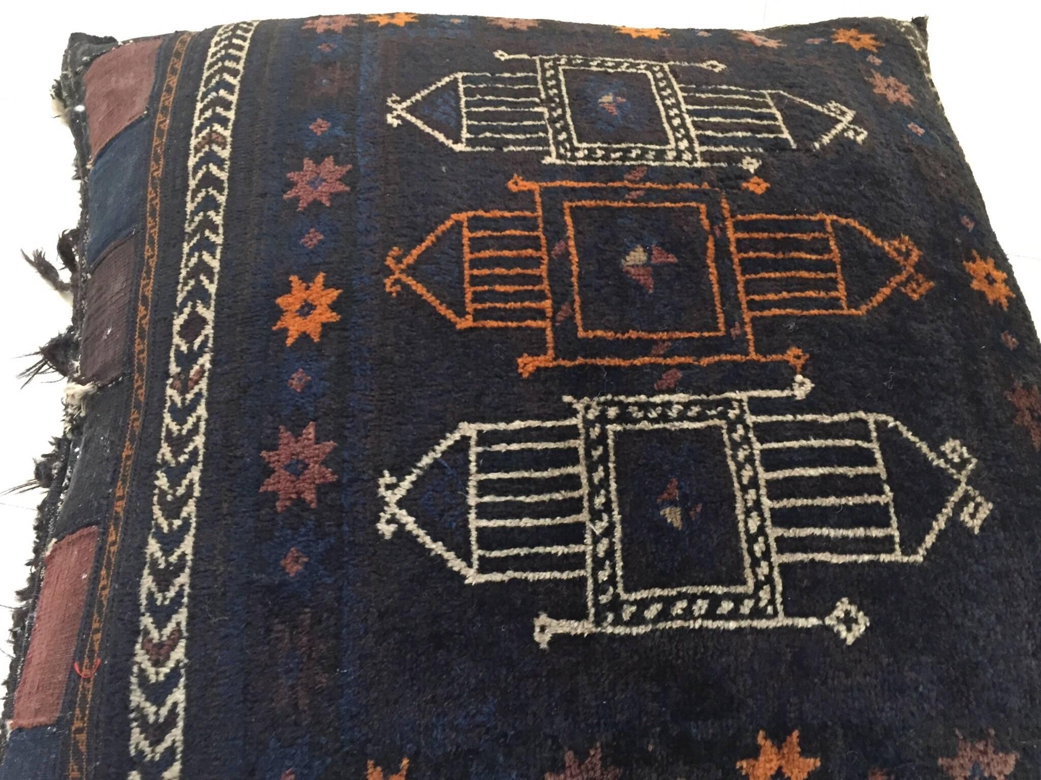 Handmade antique collectible Afghan Baluch camel saddle grain tribal bag,
circa 1880s, this large tribal camel grain bag was filled and made into a large floor pillow.
This tribal textile top rug has beautiful deep blue and black shades with soft