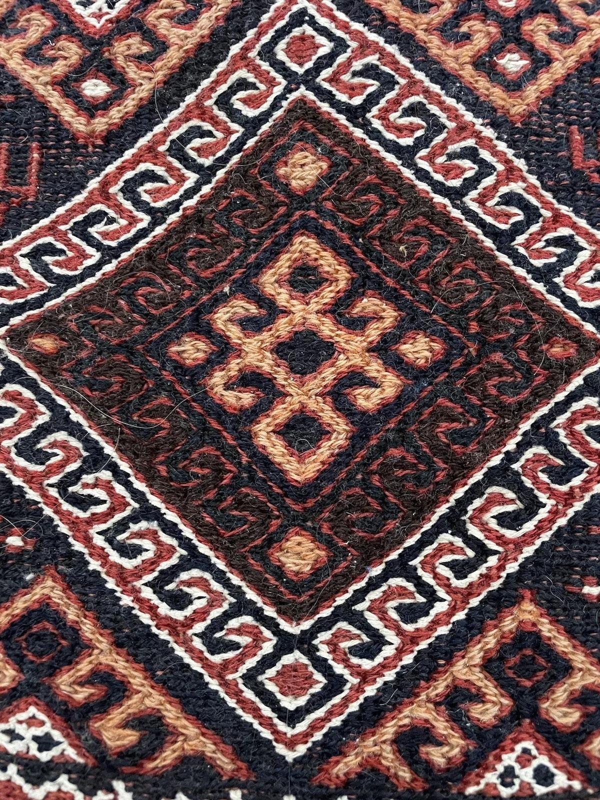 Entdecken Sie den Charme der nahöstlichen Handwerkskunst mit dieser handgefertigten antiken persischen Sumak-Salztasche, einem echten Sammlerstück aus der Zeit um 1900. Die 40 x 47 cm große Wolltasche weist komplizierte geometrische Muster in