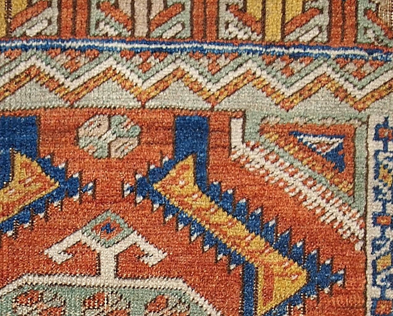 Antique collectible Turkish Yastik rug. This rug has bright orange field with geometrically designed elements in yellow and blue shades. The center and two end are in light green color. The borders are beige. Beautiful little masterpiece.
 