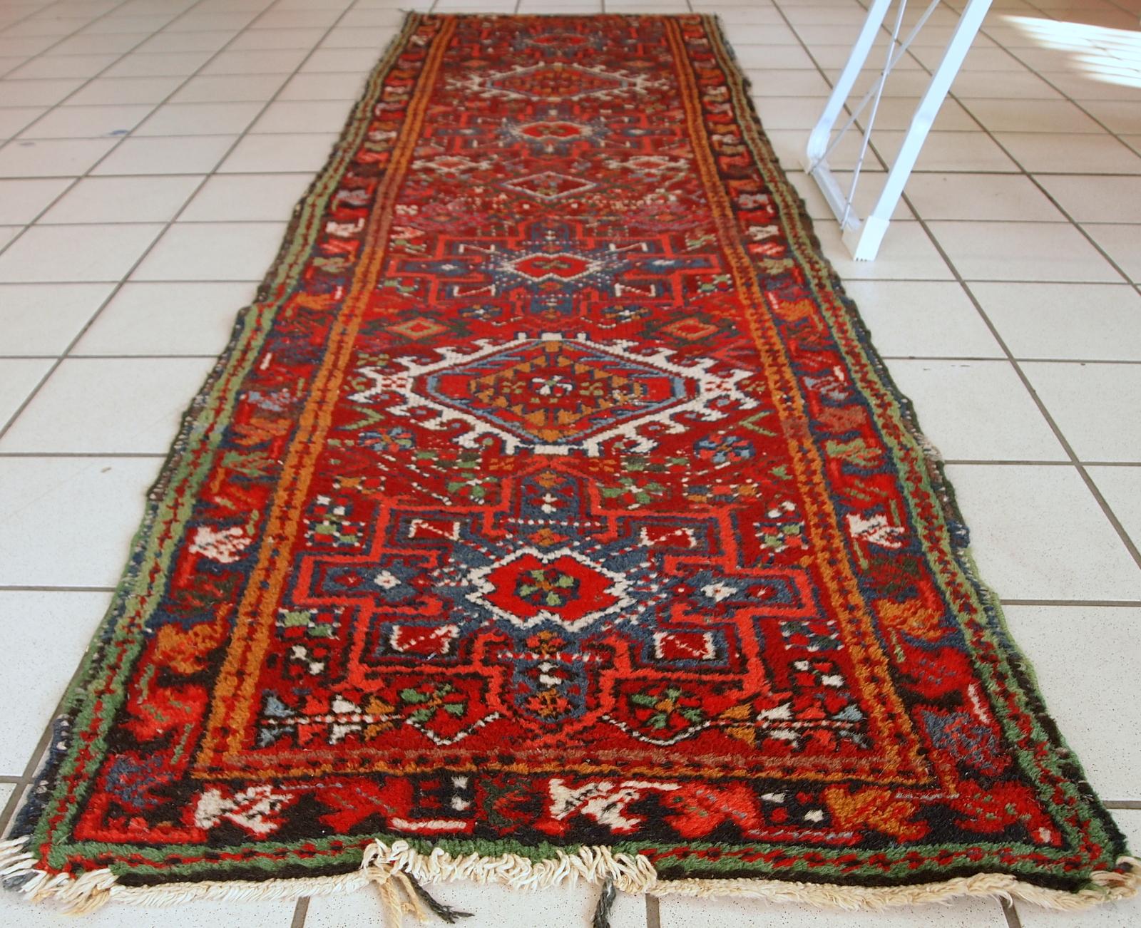 Handmade antique Karajeh style runner in distressed condition. It has been made in the beginning of 20th century in red wool.

- Condition: Distressed,

- circa 1920s,

- Size: 2.2' x 7.7' (67cm x 236cm),

- Material: Wool,

- Country of