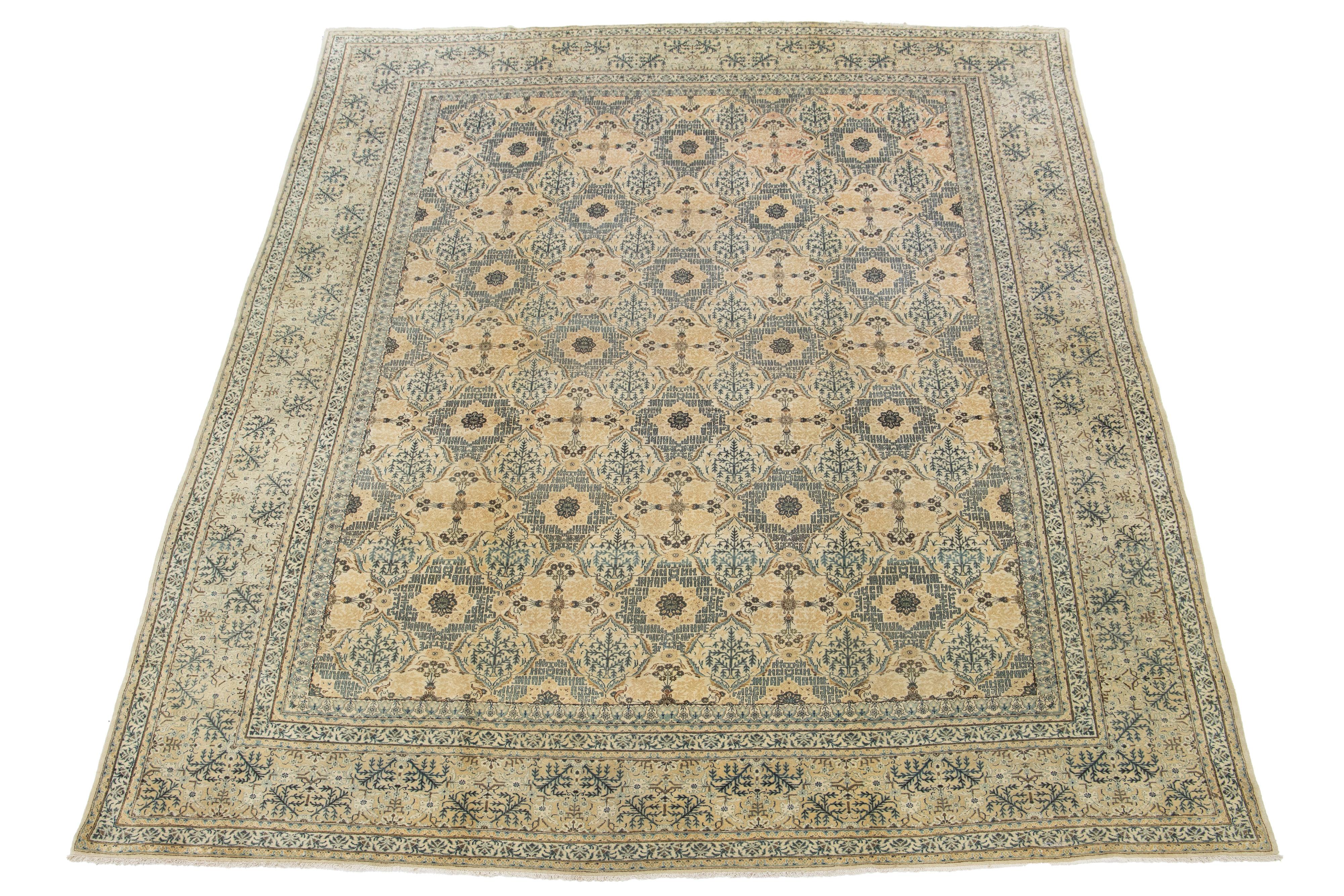 Ein handgeknüpfter antiker Kashan-Teppich mit einem Blumenmuster auf einem beigen Feld. Grüne und braune Akzente im gesamten Stück.

Dieser Teppich misst 10'6'' x 14'.