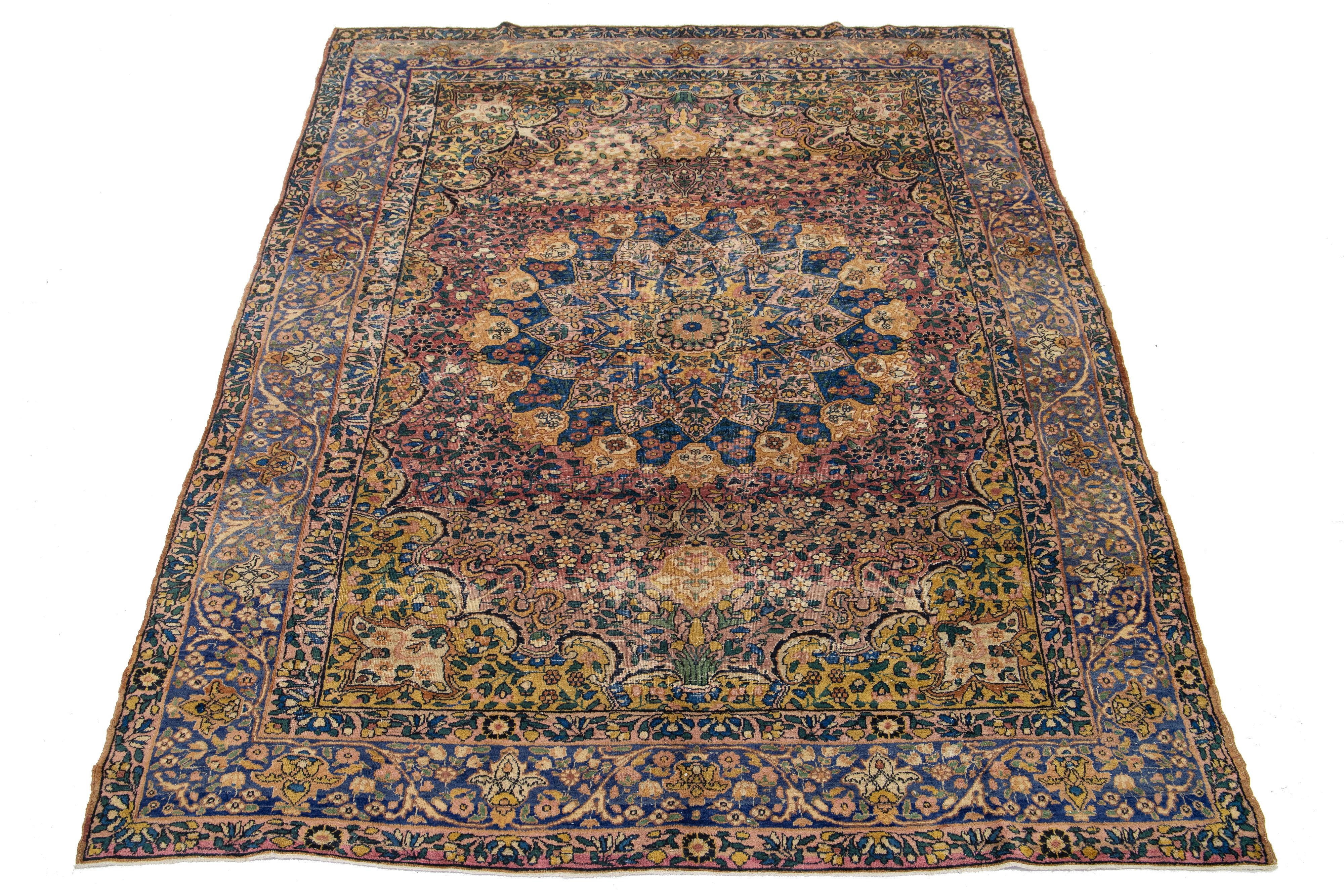Cette pièce est une antiquité des années 1920. Il présente un motif bleu, jaune et vert sur fond rouille. La bordure est ornée d'un motif de rosette.

Ce tapis mesure 6'6
