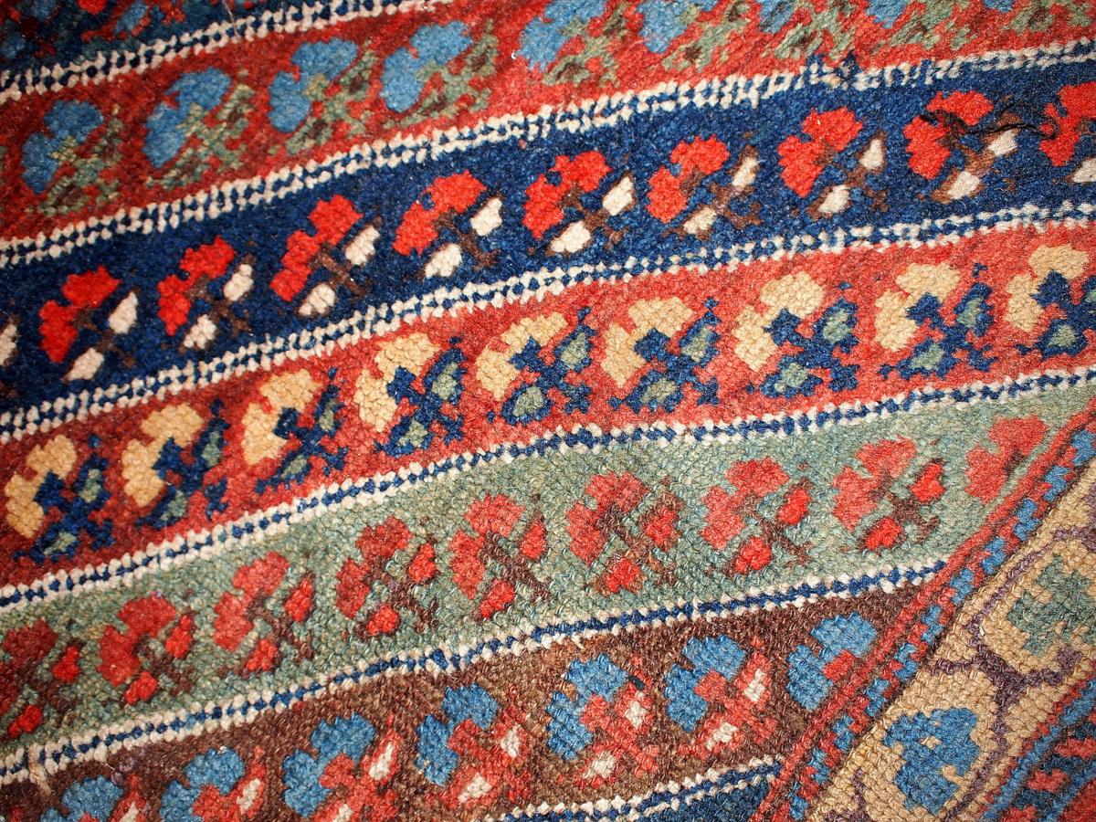 Kurd rug, late 19th century, the field comprised of polychrome diagonal stripes inset with small blossoms, within a large-scale latch-hooked 