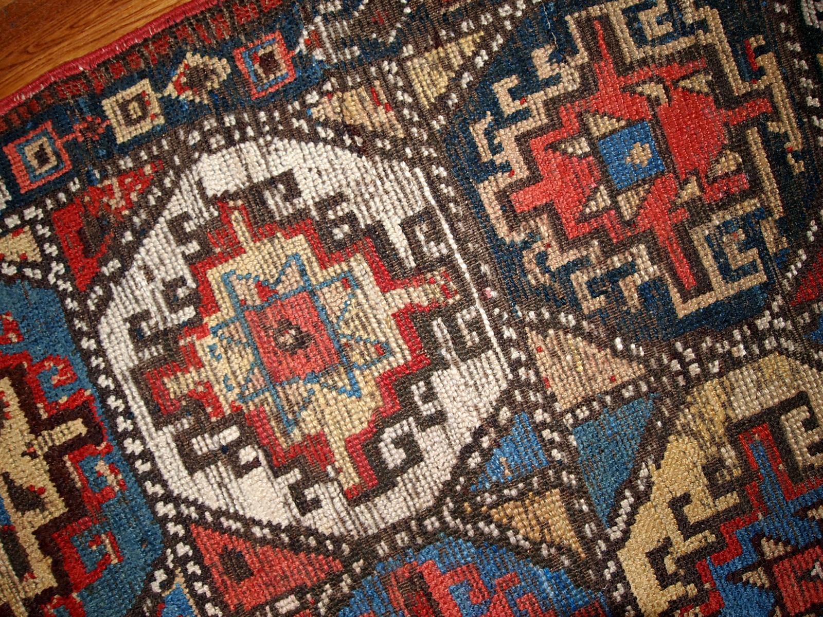 Antique collectible Kurdish rug in colorful shades and tribal ornaments. The rug is in a good shape for it's age, has some age wear. Measures: 3.5' x 4.6' (106cm x 140cm).