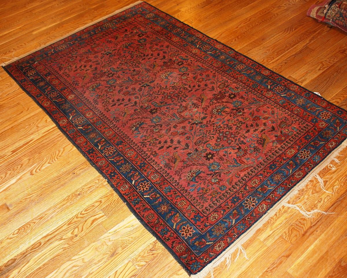 Beautiful antique Lilihan rug in rust and blue shades with garden design and birds.
 