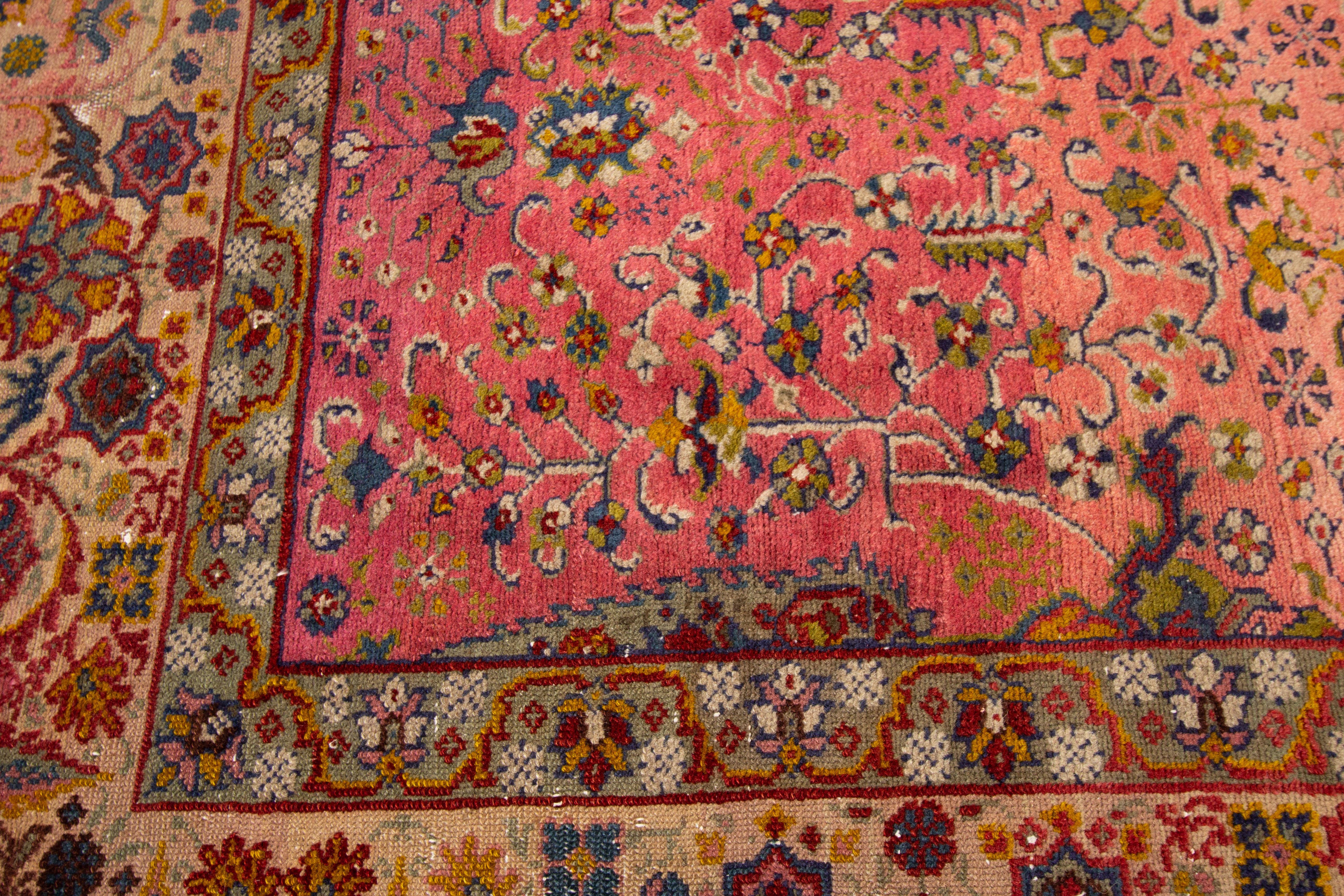 Beautiful Antique Marbediah Israeli handknotted wool rug with a Roseberry color field. This piece has a beige frame and multicolor accents in an all-over geometric floral design.

This rug measures: 7'4