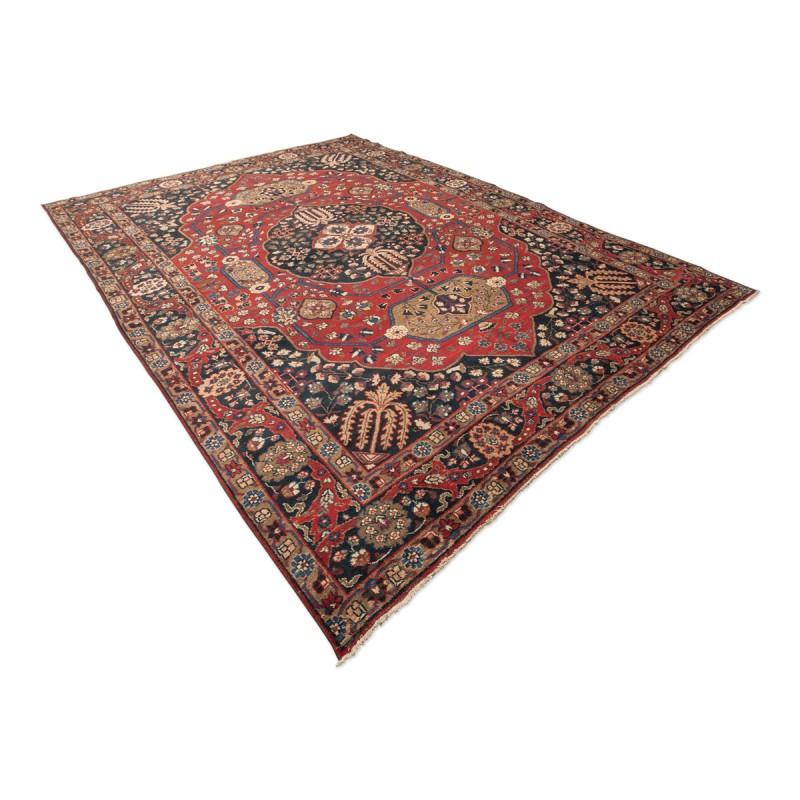 Handmade wool rug from the 20th century, around 1920.
- Very elaborate classic design with a large central medallion on a burgundy background.
- Four very worked corners with intertwined flowers.
- The edge is very elegant. A series of palmettes and