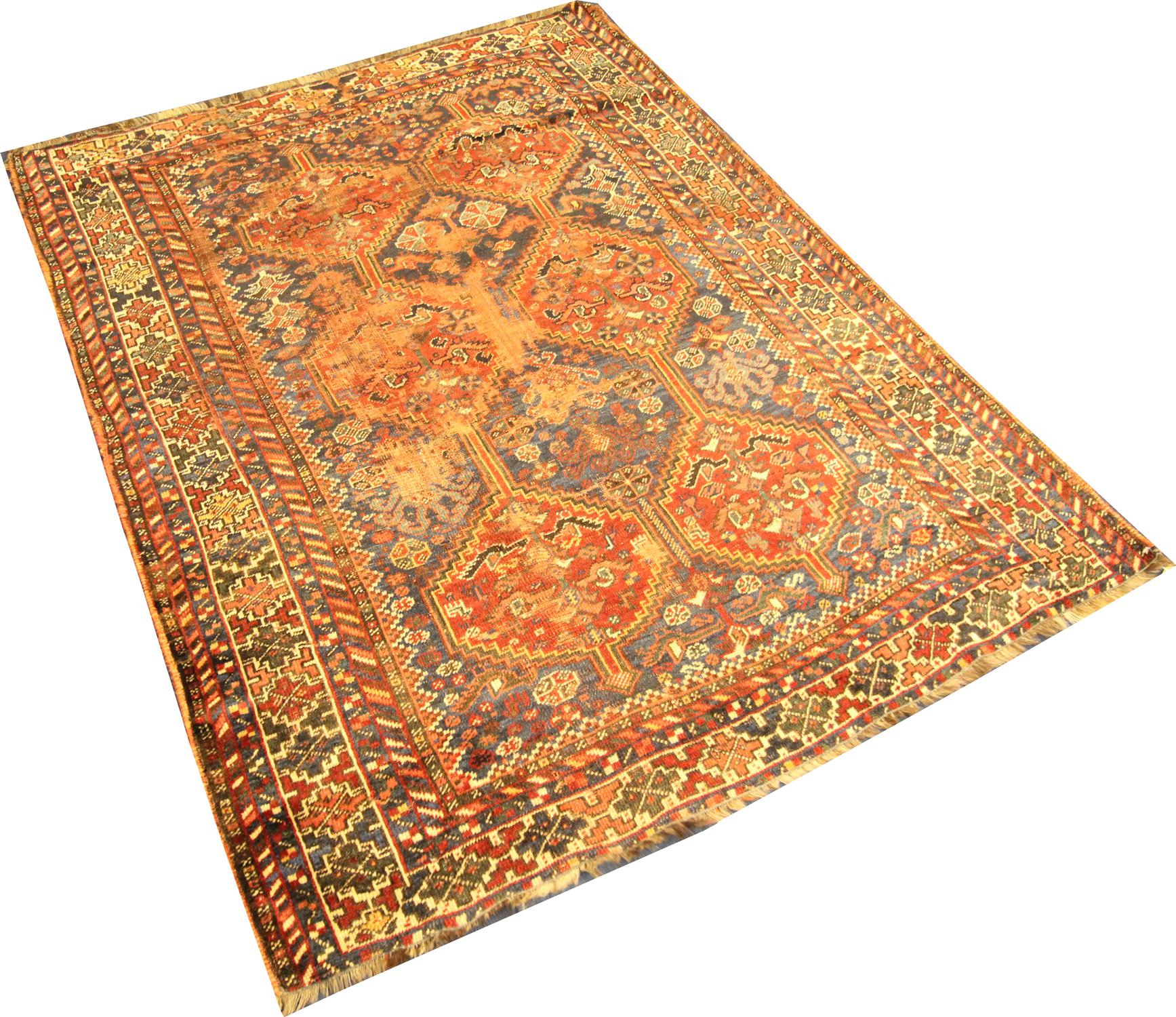 This fine wool rug was woven by hand in Azerbaijan, a country in the Caucasus region known for there bold designs. The central design features a tribal motif pattern woven in orange, beige and cream on a blue background. A layered geometric border