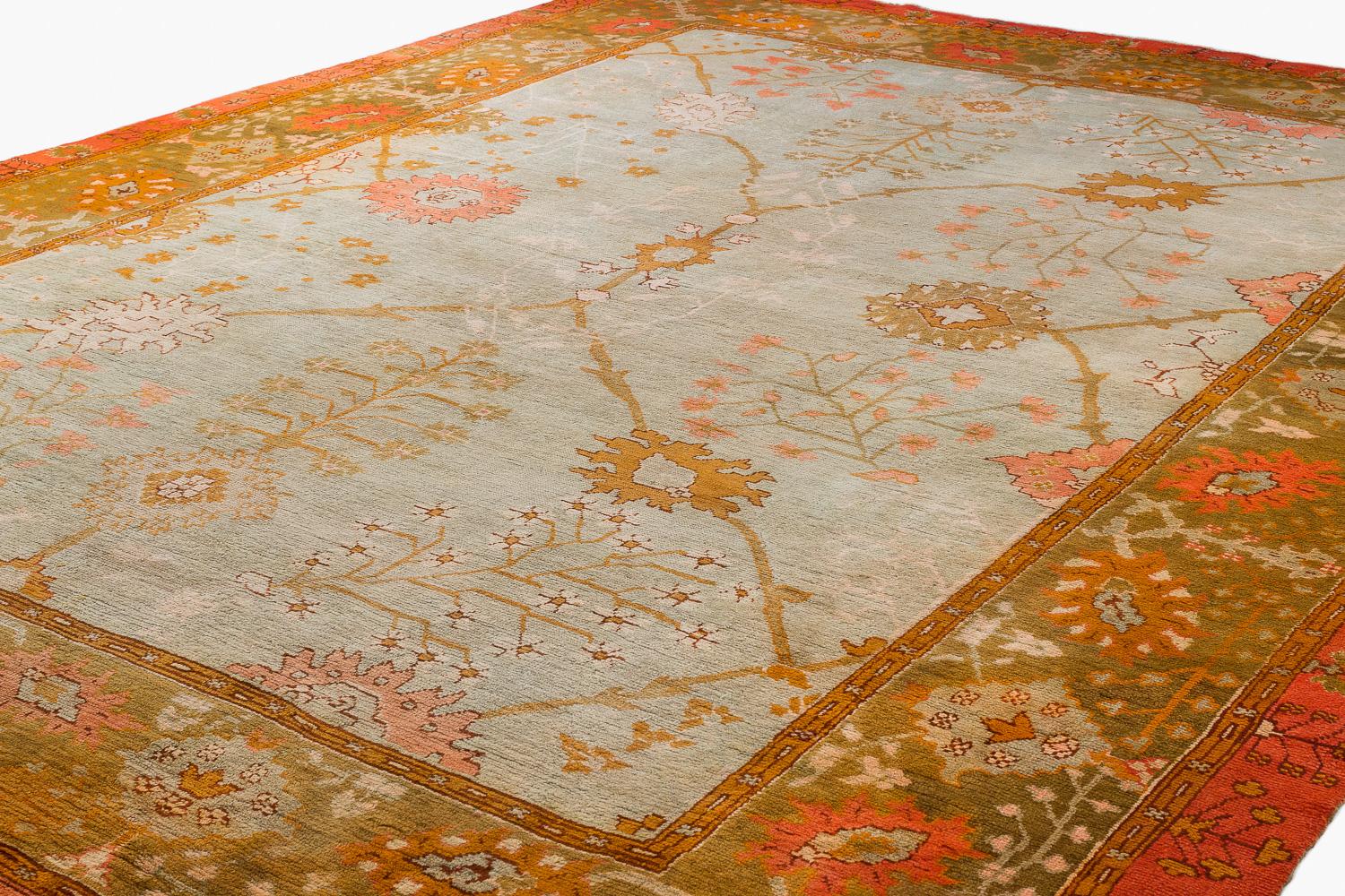 This antique Ouskak is an exceptional piece. This type of Oushak is very desirable based on the design and colors. The beautiful colors are vibrant and inviting featuring a celadon field with a large orange border and pops of green. The design has a