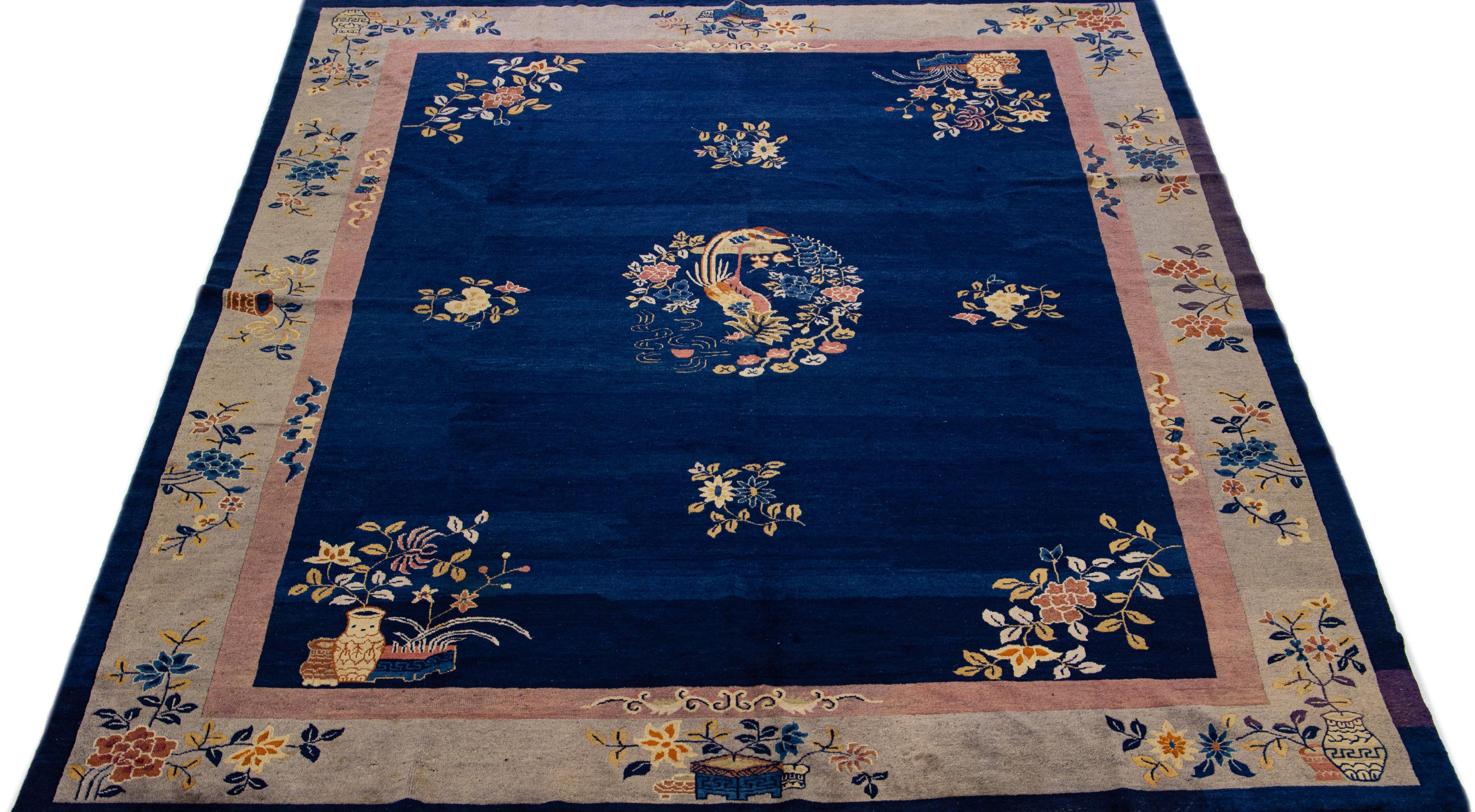 This luxurious antique Peking Chinese hand knotted wool rug features a navy blue field adorned with a designed frame and multi-colored accents in a stunning all-over Chinese floral motif.

This rug measures: 9' x 11'7