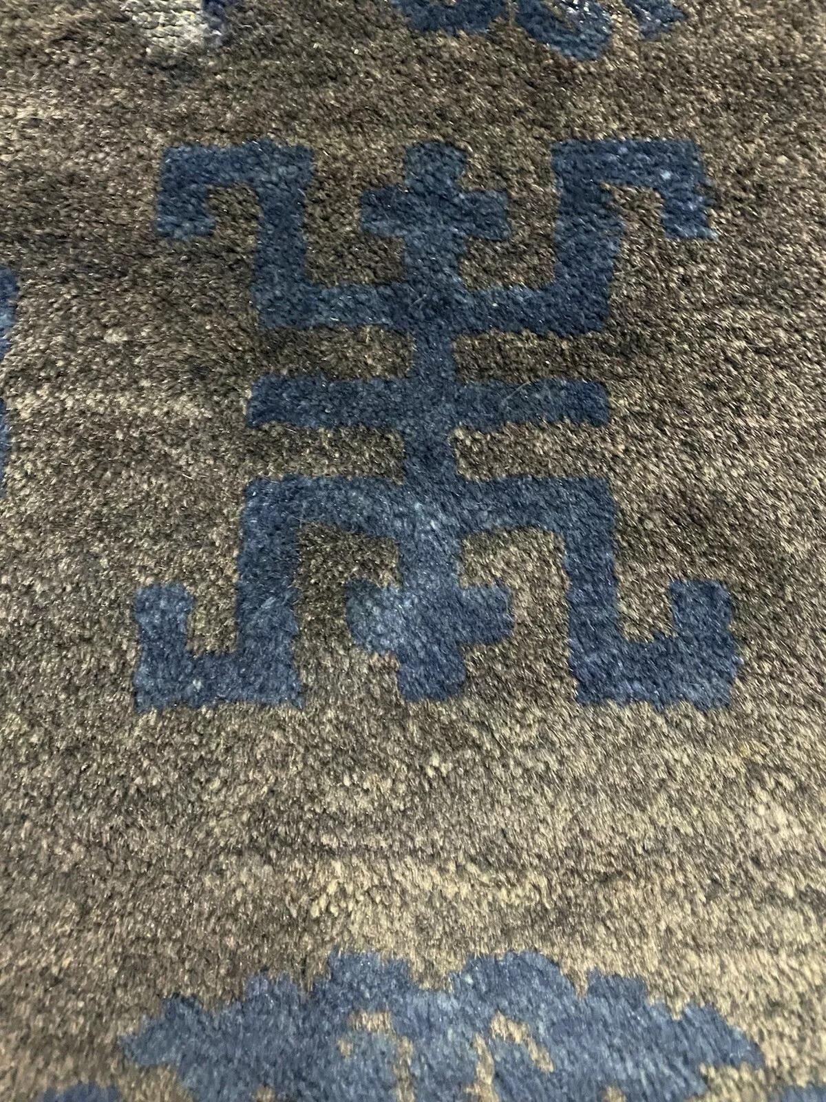 Entrez dans le riche héritage de l'artisanat chinois avec ce tapis ancien en laine de Pékin datant des années 1900. Réalisée à la main avec des détails méticuleux, cette pièce présente un jeu captivant de motifs géométriques d'un bleu profond se