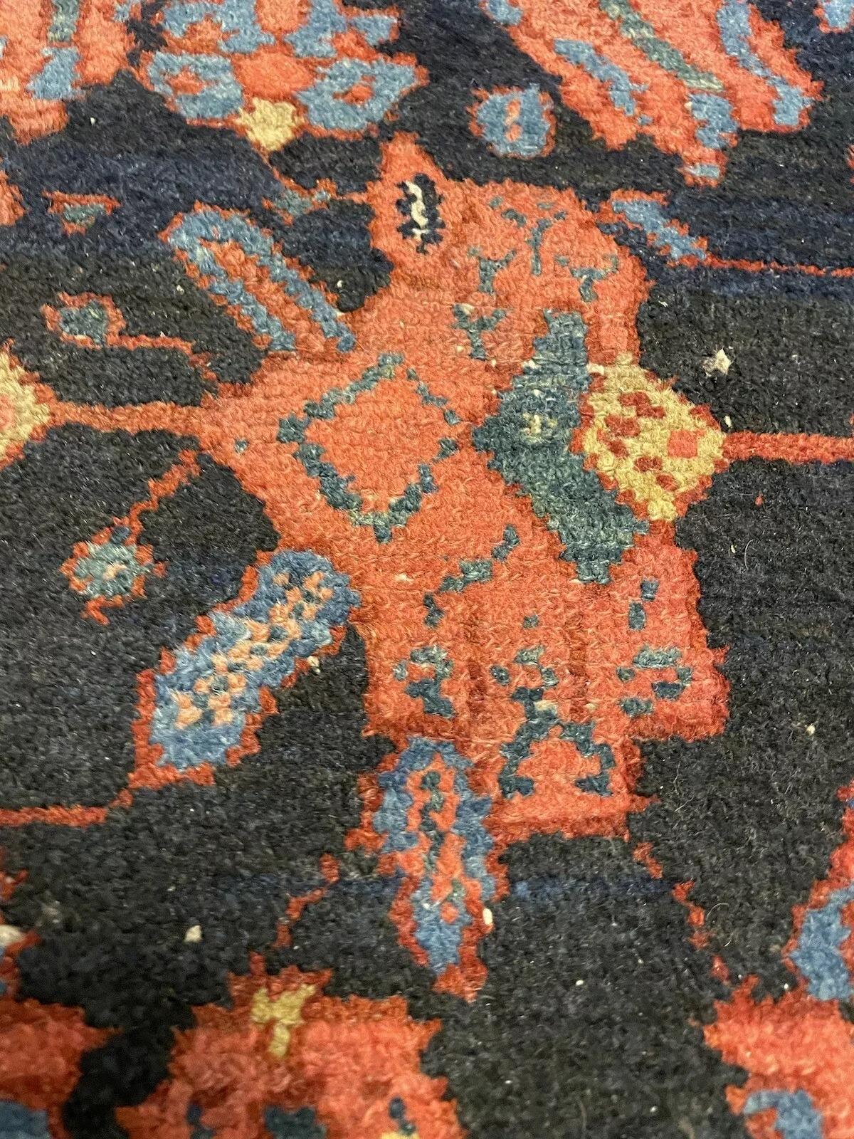 Ce tapis persan antique Bakhtiari, fait à la main et datant des années 1920, est un magnifique exemple de l'artisanat du Moyen-Orient. Mesurant 4,4 pieds (134 cm) de largeur et 6,4 pieds (194 cm) de longueur, cet exquis tapis de laine est