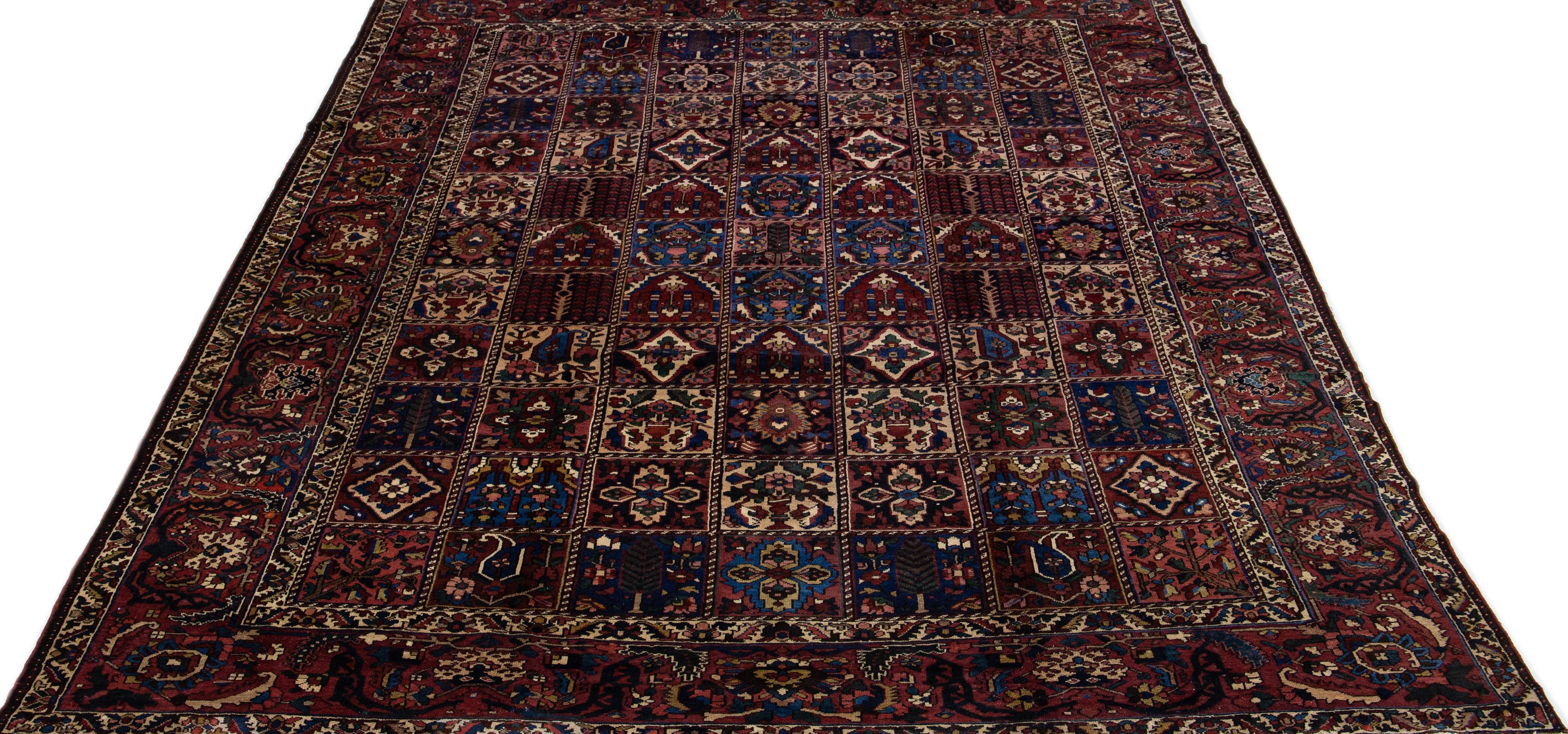 Beautiful Antique Bakhtiari hand-knotted wool rug with a burgundy color field. This Persian piece has an all-over classic floral multicolor design.

This rug measures 10'4