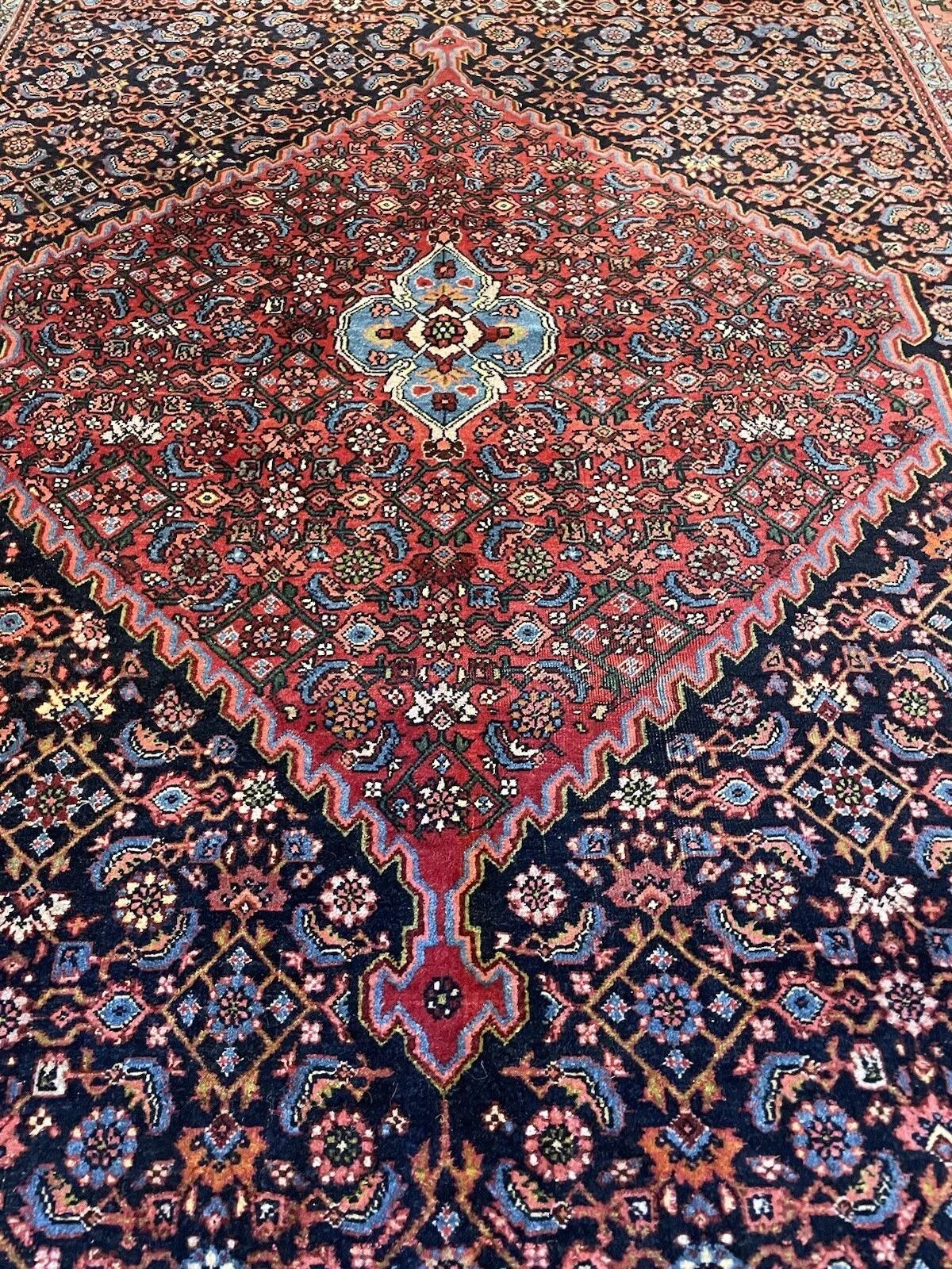 Ce tapis ancien persan Bidjar, tissé à la main, est un objet d'une grande qualité artisanale. Il a été fabriqué dans les années 1920. Il mesure 4,6 pieds (140 cm) de largeur et 7,3 pieds (222 cm) de longueur. Ce très beau tapis en laine est en bon