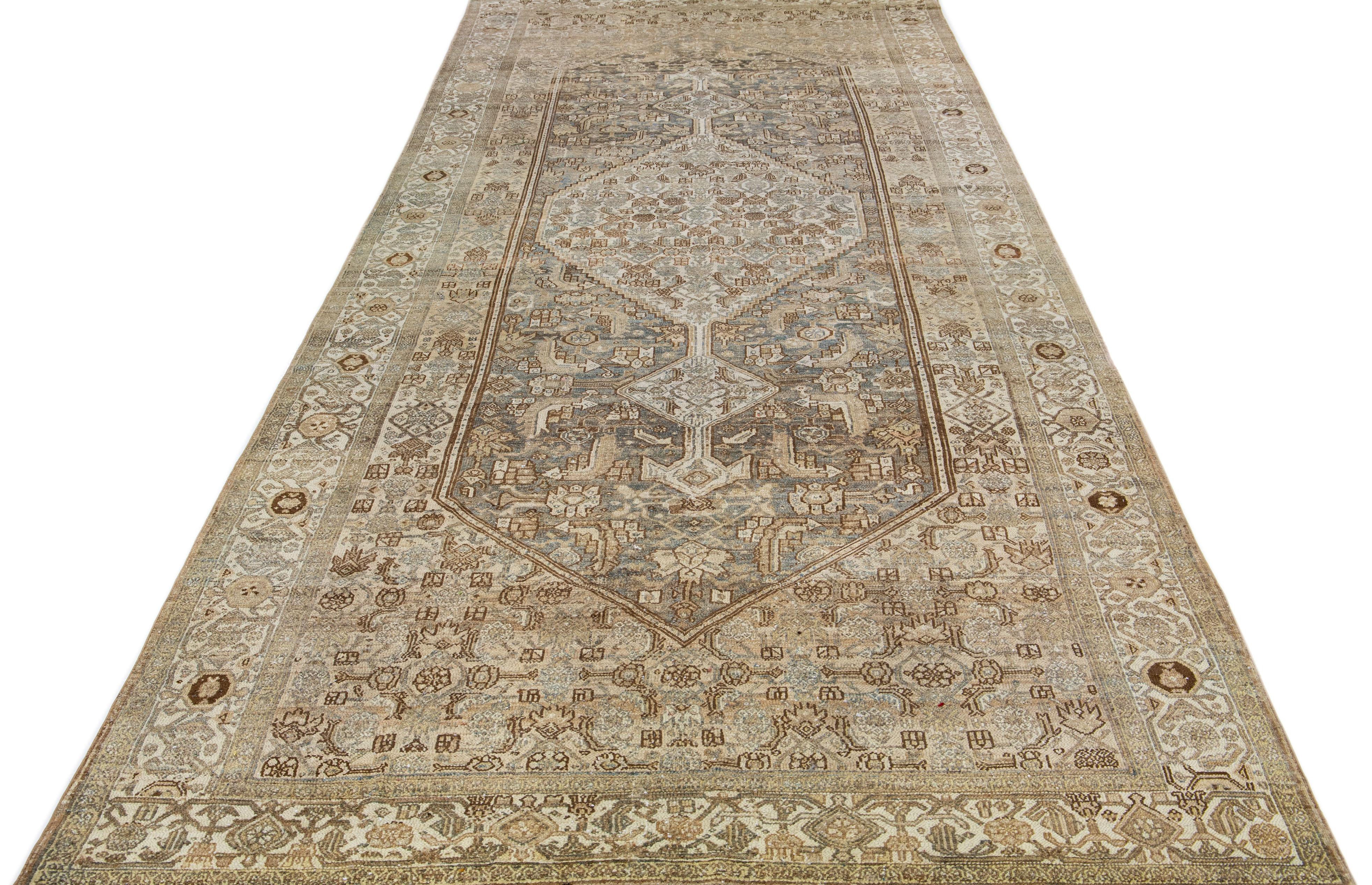 Beautiful antique Persian hand-knotted wool rug with a blue color field. This piece has blue and brown accents in a gorgeous all-over medallion design.

This rug measures: 6' 9' x 16' 2