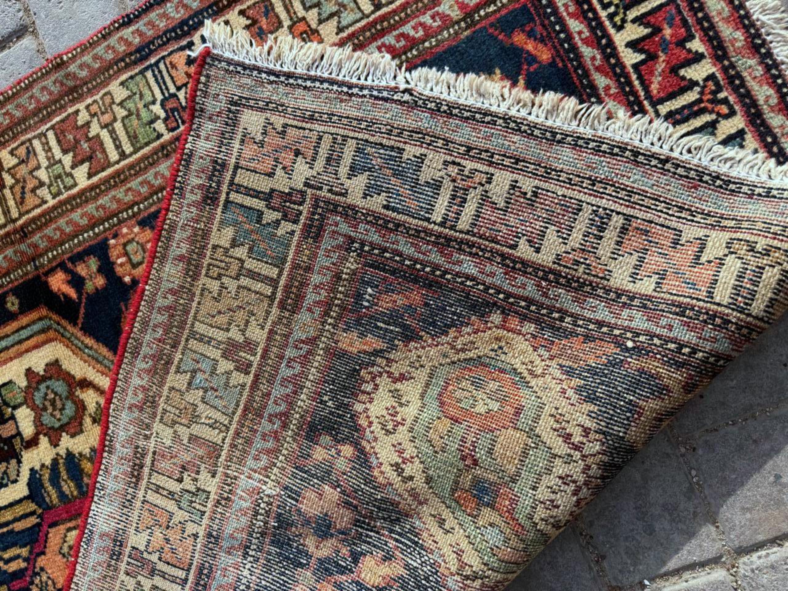 Questo squisito tappeto antico persiano Hamadan fatto a mano è un esempio lampante della durata e della ricchezza artistica della tessitura mediorientale dell'inizio del XX secolo. Risalente agli anni '20, questo pezzo offre un immediato senso di