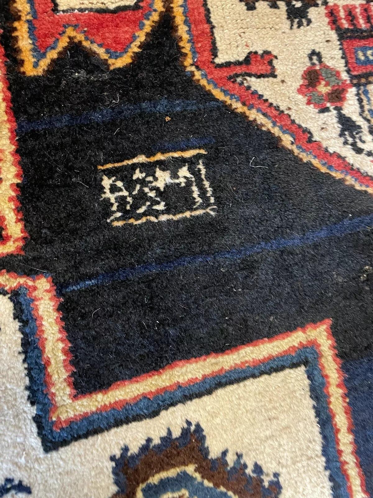 Ce tapis persan Hamadan ancien, fait à la main et datant des années 1920, est un bel exemple de l'artisanat et du design traditionnels. Mesurant 118 cm de large et 235 cm de long, ce tapis en laine est en bon état, ce qui témoigne de sa qualité