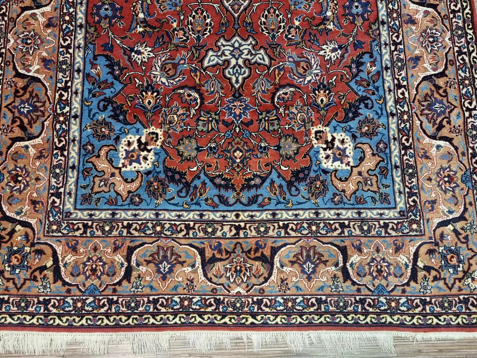 Ce superbe tapis d'Ispahan des années 1940 est un chef-d'œuvre de l'artisanat persan. Ce luxueux tapis oriental noué à la main en laine kork et en soie présente un motif floral complexe dans de riches tons rouges. Son élégance et sa beauté
