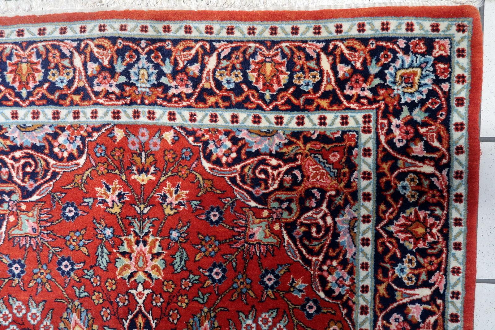 Introducing our remarkable Handmade Antique Persian Kashan Rug from the 1930s. This exquisite rug showcases a vibrant and busy design with a captivating floral motif, set against a backdrop of rich red, navy blue, turquoise, pink, and beige colors.