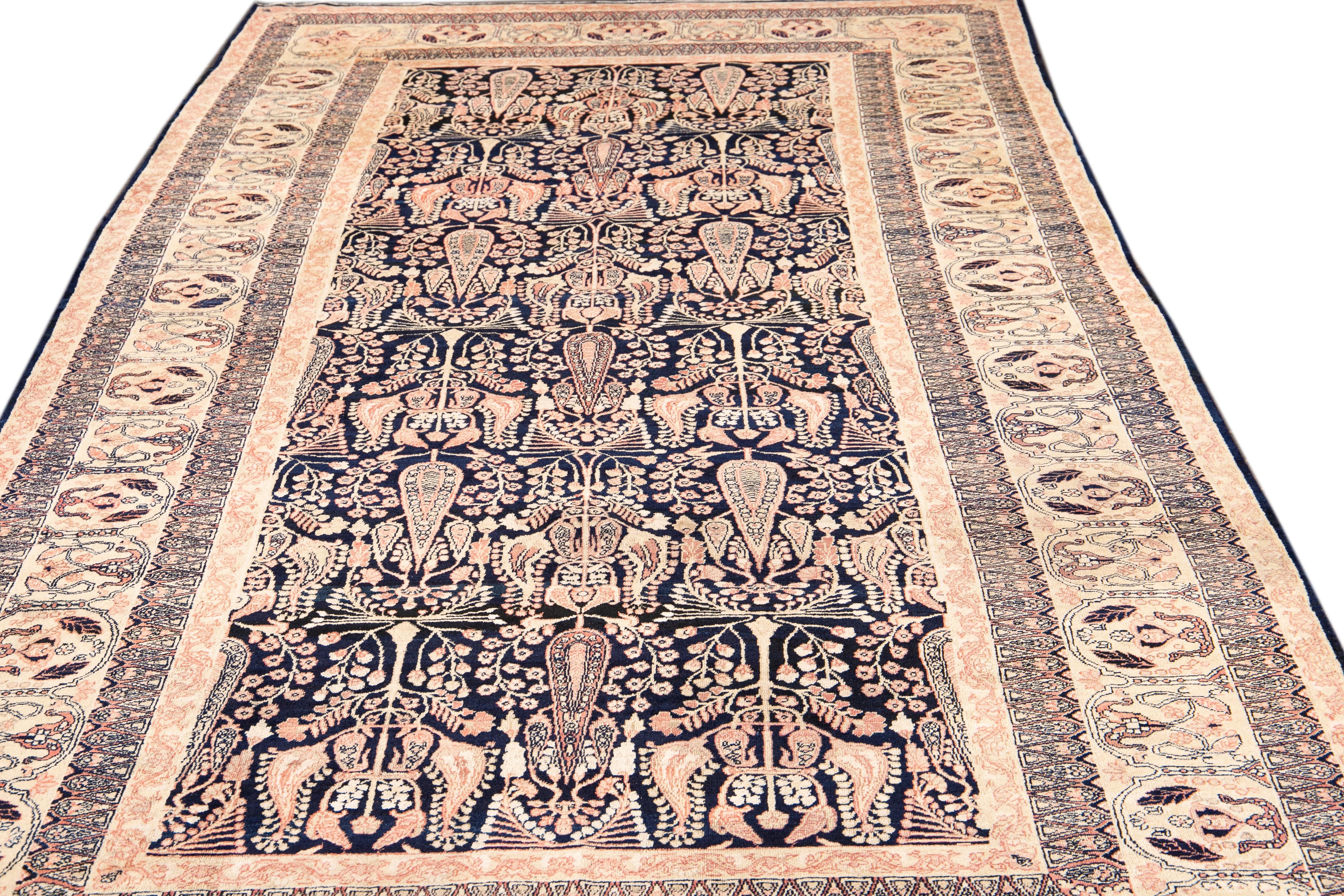 Beautiful antique Kerman hand knotted wool rug with a dark blue field. This Persian rug has peach and beige accents in a gorgeous all-over floral pattern design.

This rug measures: 5'11
