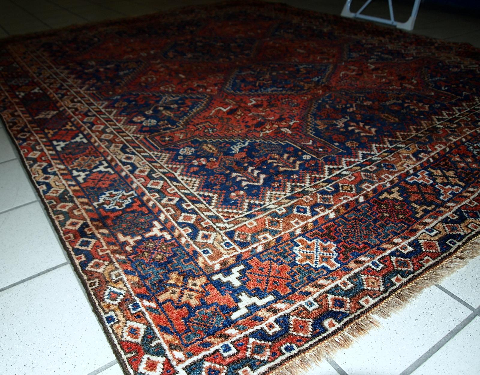 Handmade antique Khamseh rug from the beginning of 20th century with symmetric design and deep shades. The rug has some low pile.

-condition: some low pile,

-circa: 1900s,

-size: 6' x 6.4' (156cm x 194cm),

-material: wool,

-country of origin: