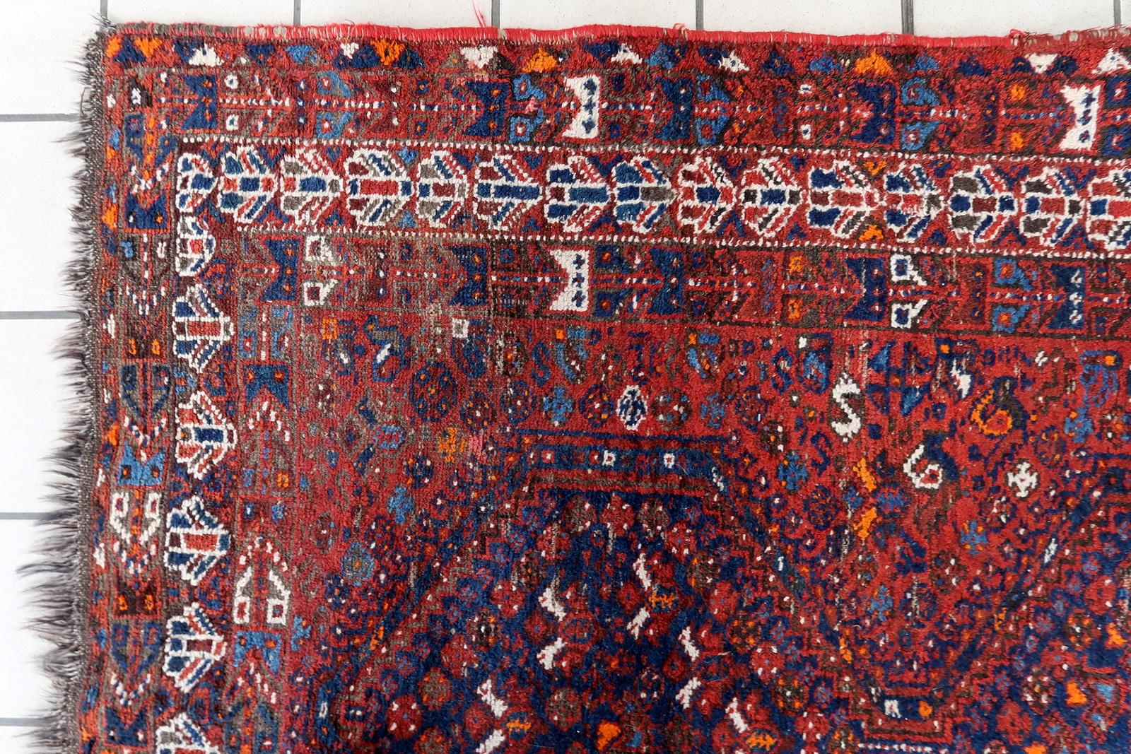 Tauchen Sie ein in die Welt der zeitlosen Schönheit mit unserem handgefertigten antiken persischen Khamseh-Teppich aus den 1920er Jahren. Mit den Maßen 4,3' x 6,6' (132cm x 203cm) blickt dieser Teppich auf eine reiche Geschichte und exquisite