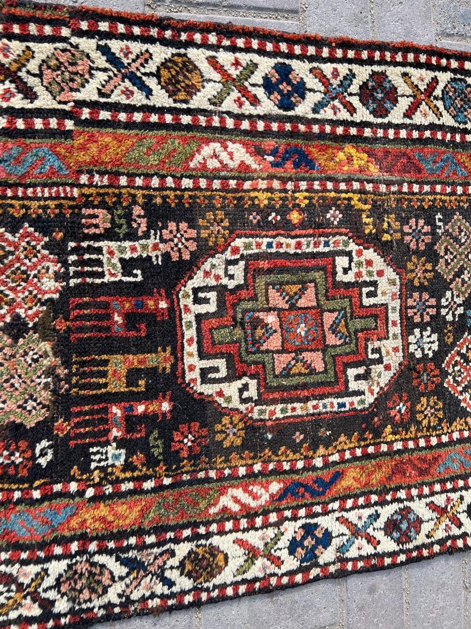 Laissez-vous séduire par l'attrait de l'héritage persan avec ce tapis de course persan kurde ancien, fait à la main, datant des années 1900. Mesurant 2,5 pieds de largeur et 11,8 pieds de longueur (76 cm x 359 cm), ce remarquable tapis de course est