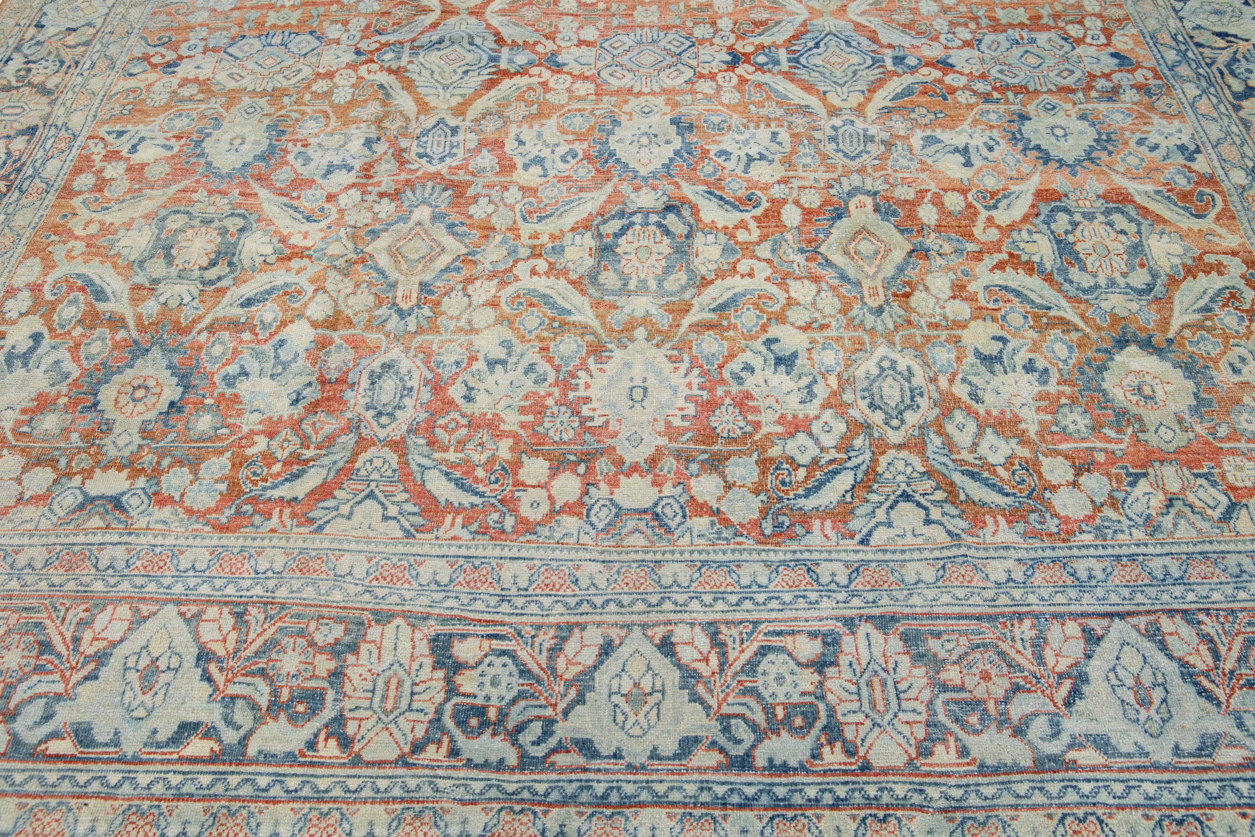 Beautiful hand-knotted antique mahal wool rug with a rust color field. This Persian rug has blue and beige accent colors in an all-over floral pattern. 

This rug measures: 9'6