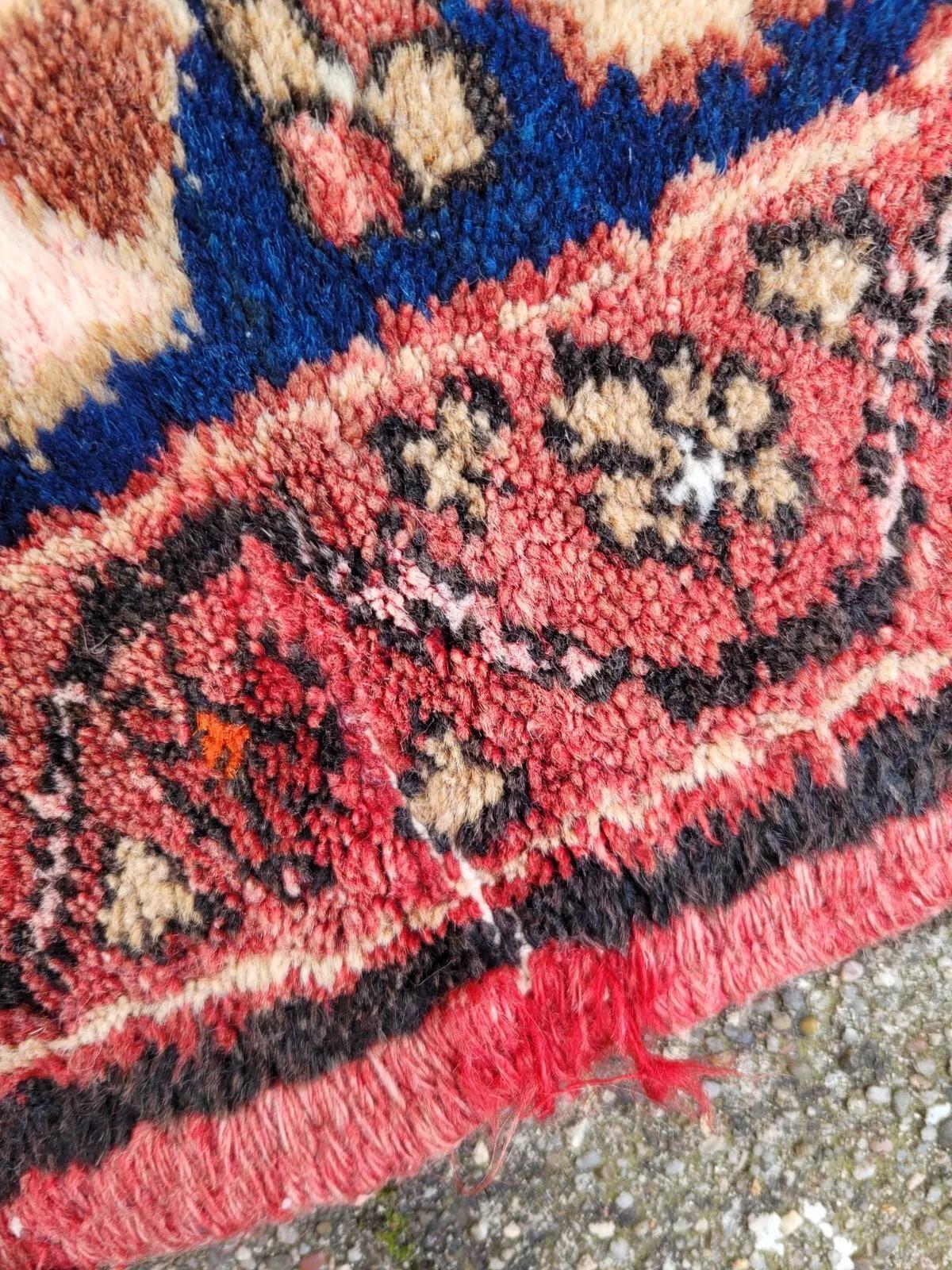 This handmade vintage Persian Malayer rug, dating from the 1950s, showcases the refined artistry and craftsmanship for which Malayer weavers are renowned. Woven in 100% wool, it features a striking symmetrical geometric composition with interlocking