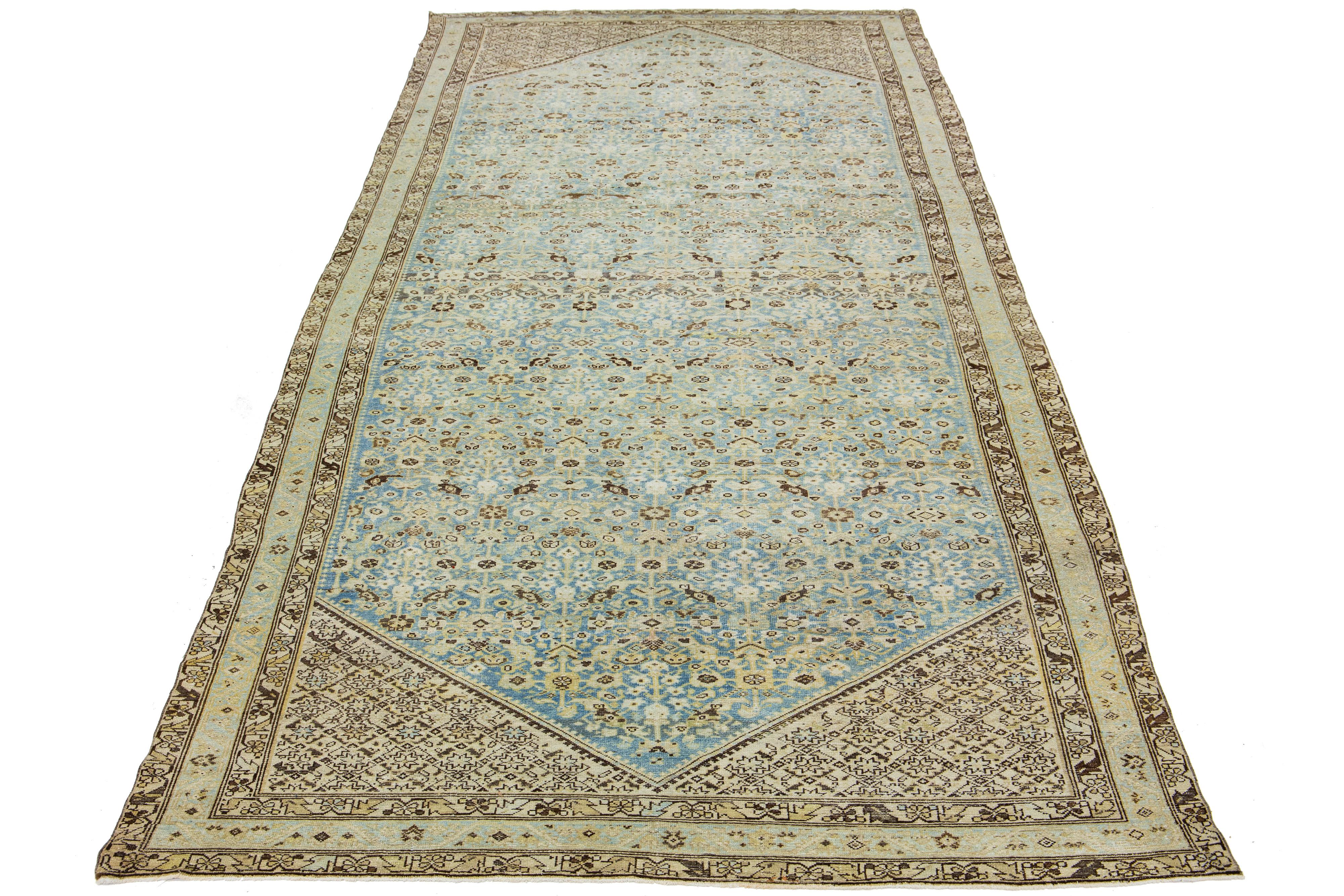 Cet exceptionnel tapis ancien persan Malayer est fabriqué à la main à partir de laine méticuleusement tissée. L'écran se compose d'un bleu clair calme à la base, rehaussé de touches brunes dans un motif classique d'une complexité