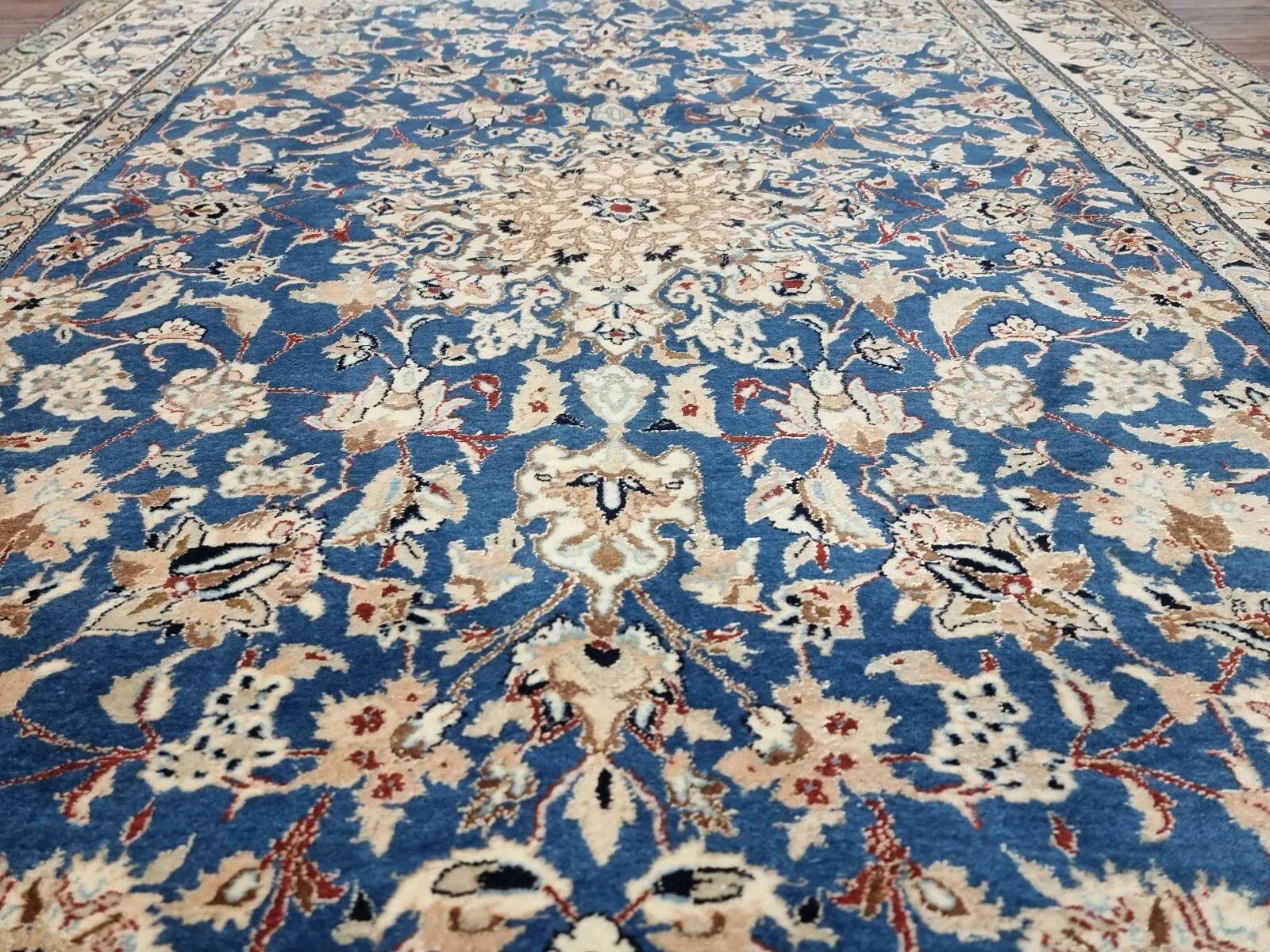 This charming antique Persian Nain rug from the 1920s is a fine example of Persian craftsmanship, celebrated for its intricate designs and high-quality materials. Made with a blend of kork wool and cotton, the rug boasts a soft texture and